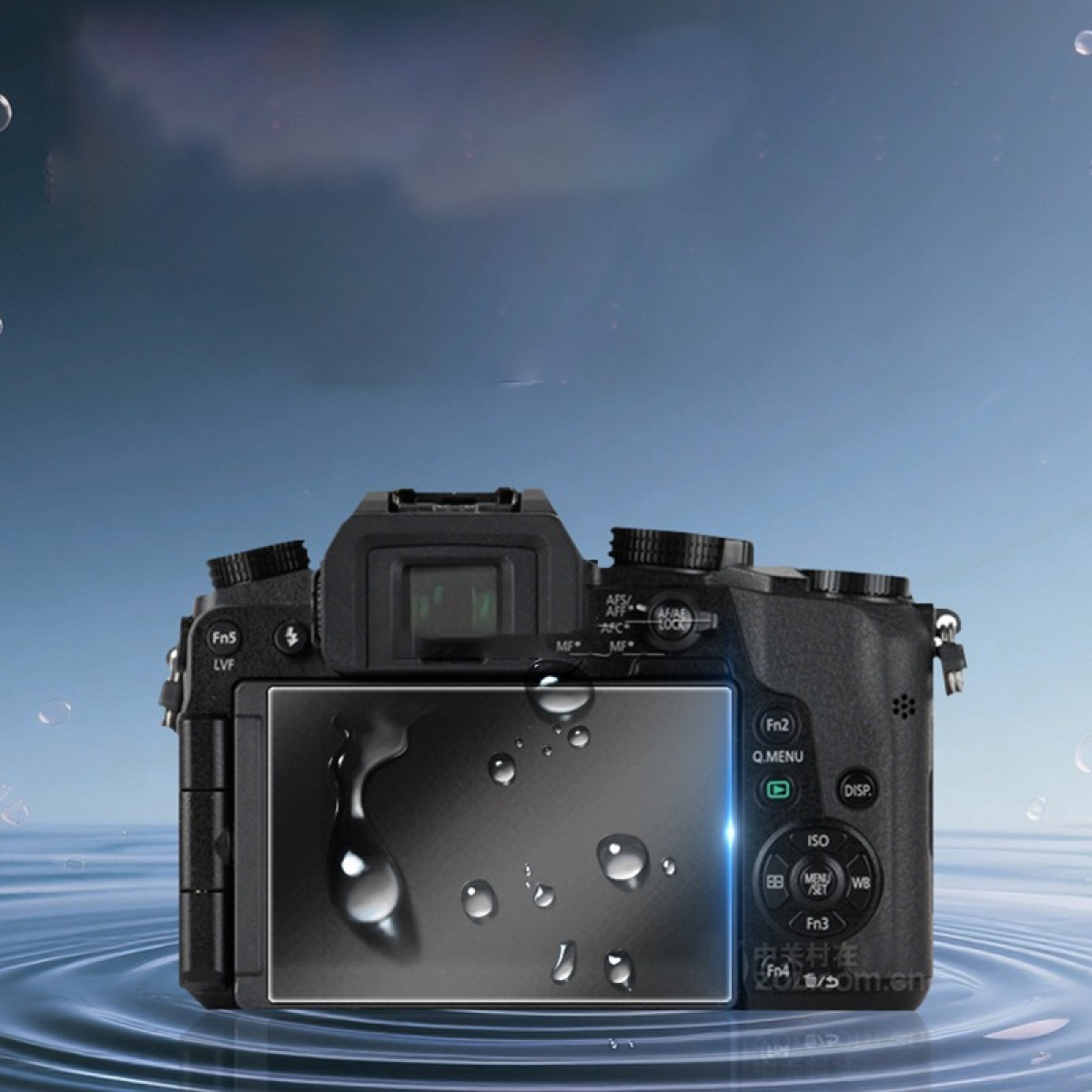 Una fotocamera nera con gocce d'acqua sullo schermo è posizionata su una superficie d'acqua. Lo sfondo è un cielo blu sfocato.
