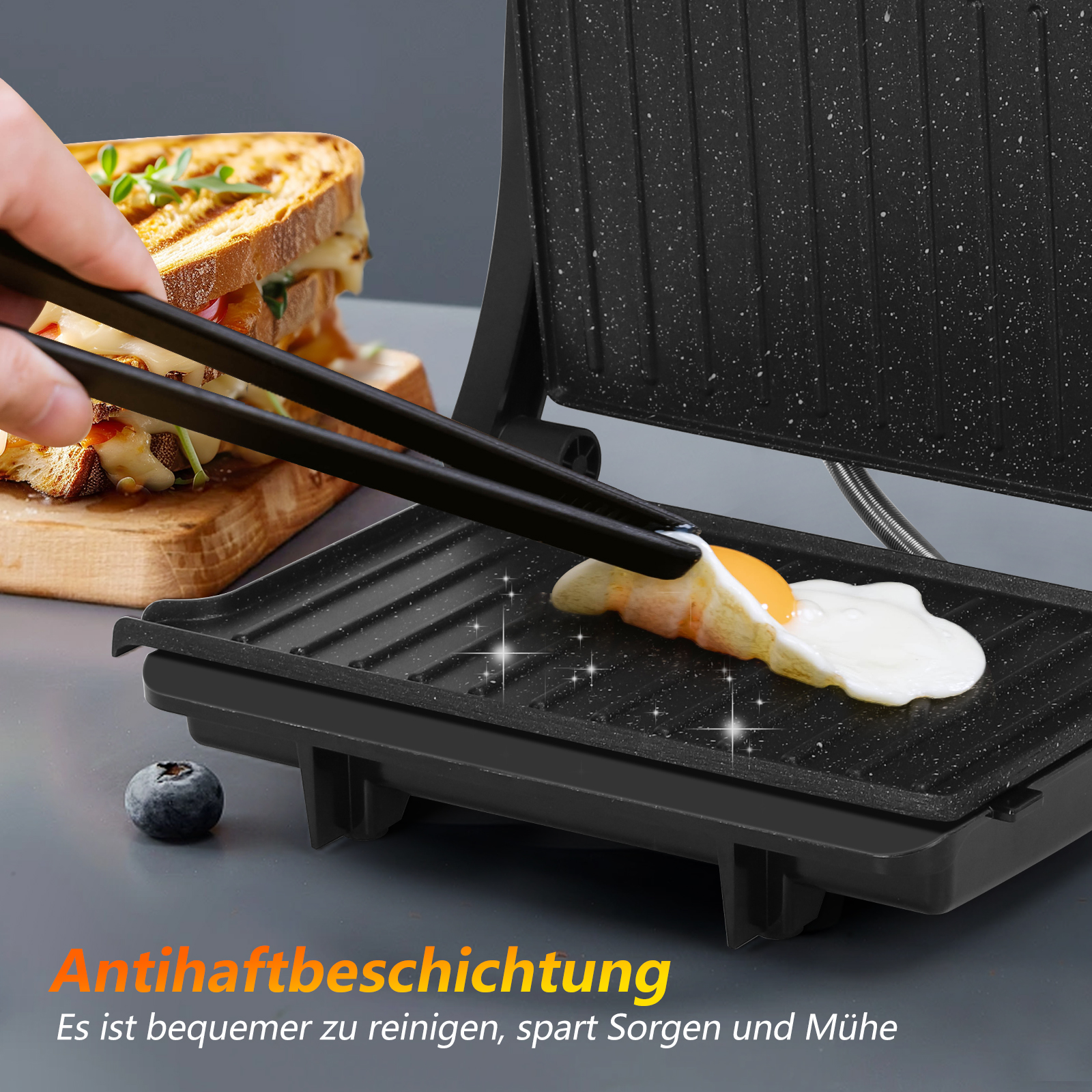 Ein Ei wird auf einem schwarzen Grill gebraten. Links ist ein Sandwich. Eine Hand hält eine Zange. Eine Blaubeere liegt in der Nähe.