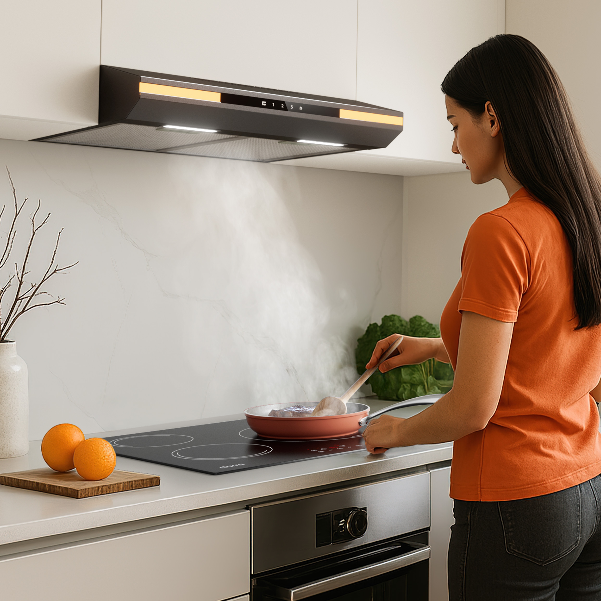 A woman in an orange shirt cooks in a modern kitchen. A pan steams on the stovetop. Oranges and a wooden board are on the counter.