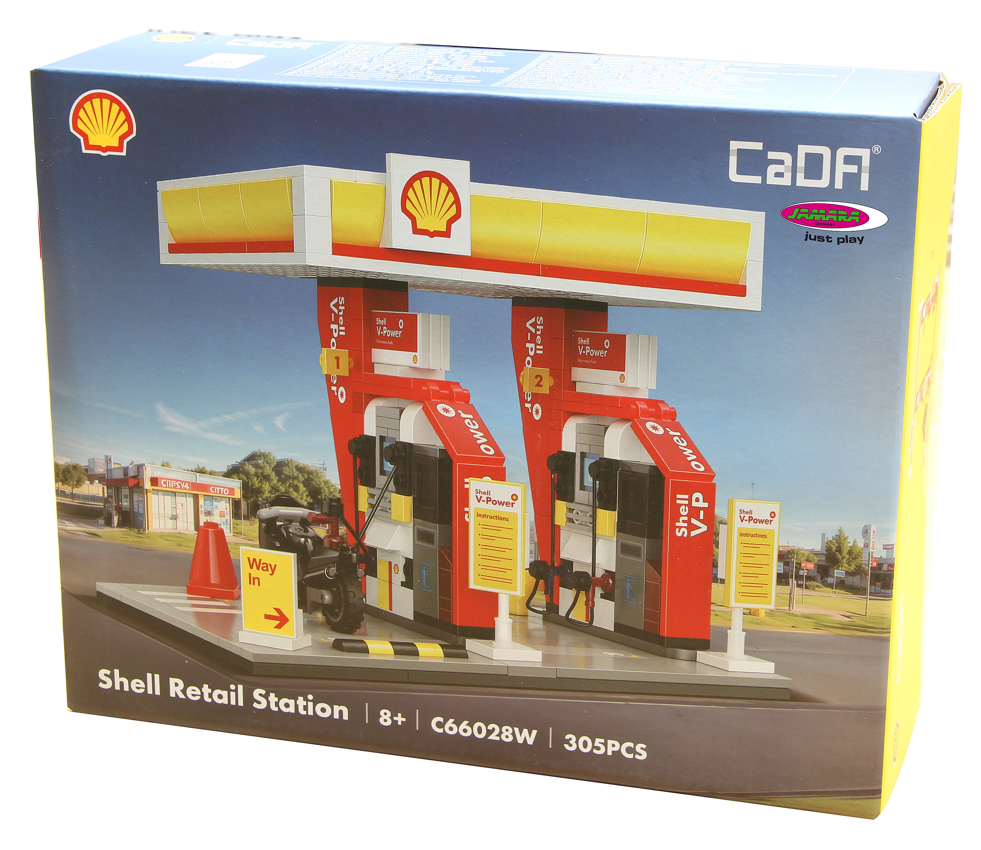 Eine Schachtel zeigt ein Shell-Tankstellenmodell mit roten und gelben Strukturen, einem Motorrad und dem Shell-Logo.