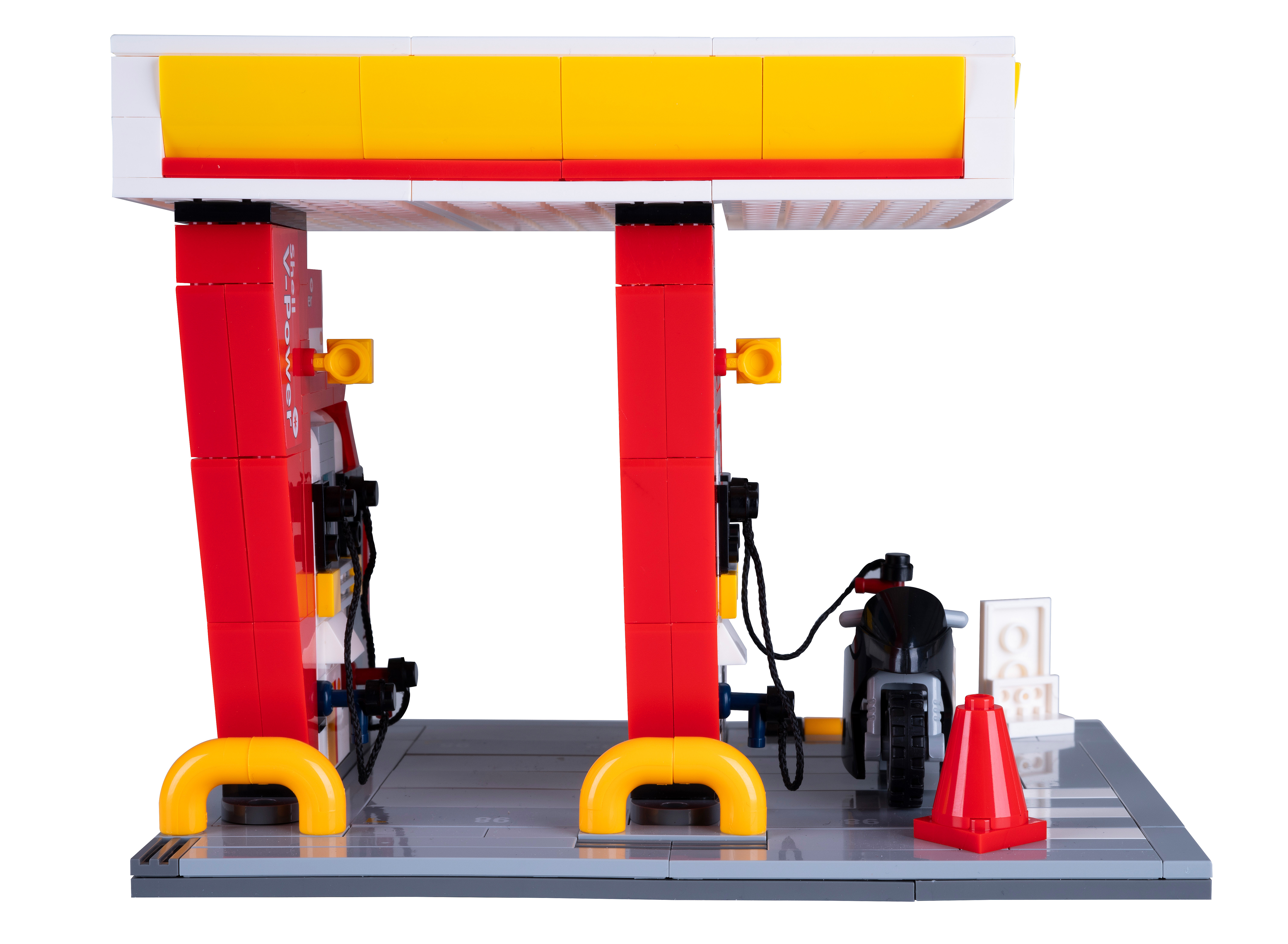 Eine Lego-Tankstelle mit Motorrad und Verkehrskegel. Die Station hat rote und gelbe Farben.