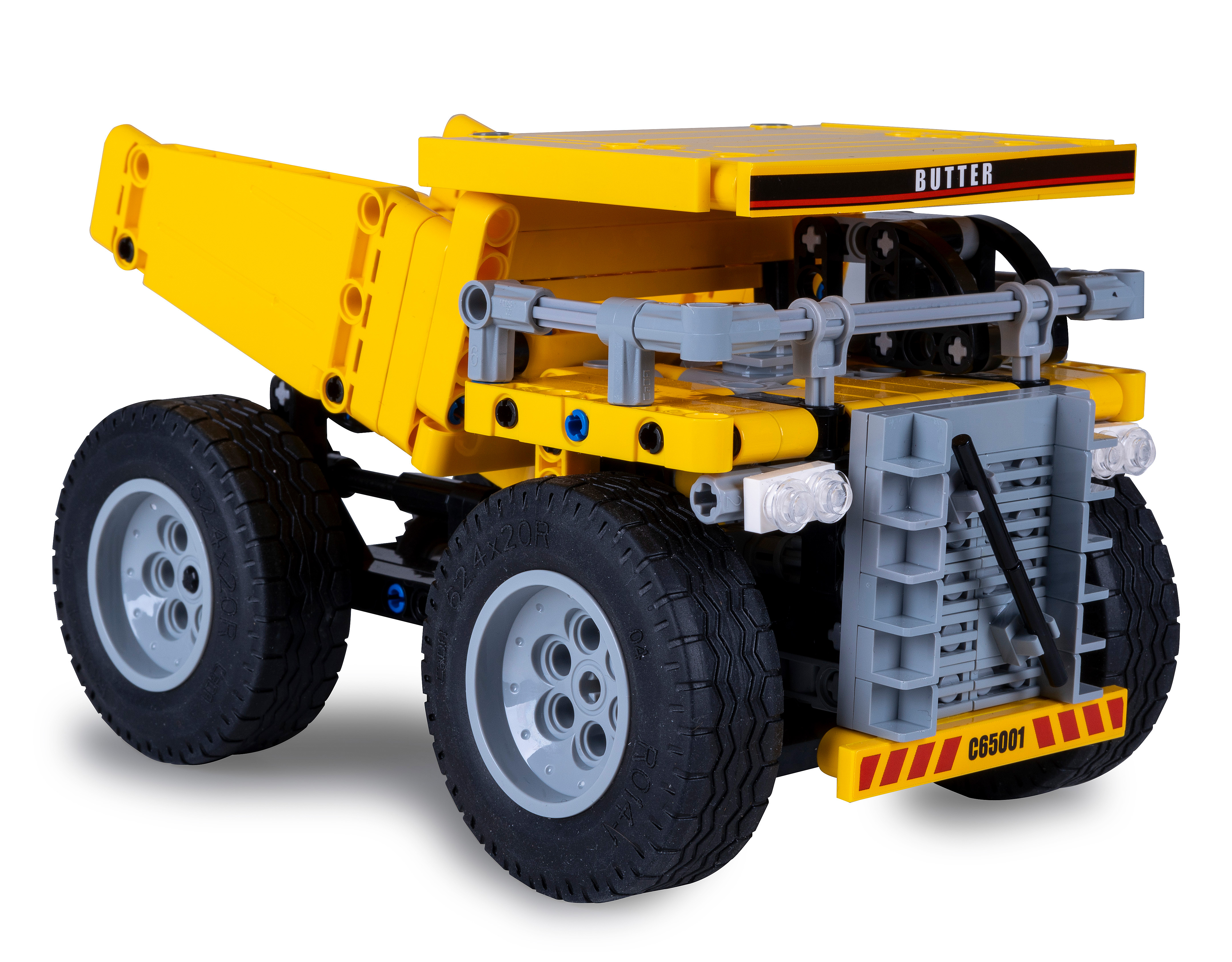 Ein gelber Lego-Truck mit schwarzen Reifen, grauen Rädern und dem Aufdruck 'BUTTER'. Er steht auf weißem Untergrund.