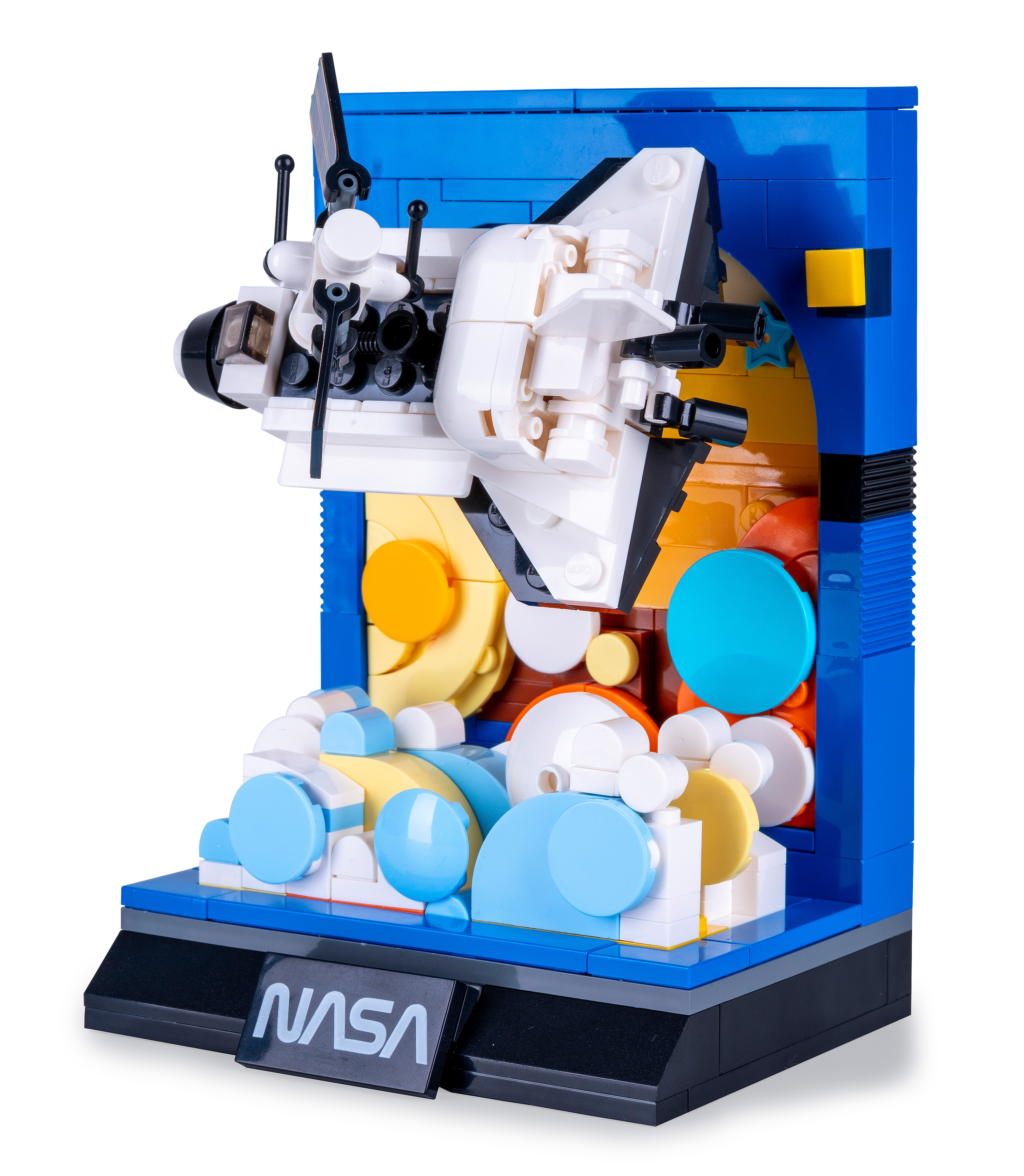 Ein Lego-Modell des NASA-Space Shuttles, weiß und schwarz, in einem blauen Rahmen mit gelben, orangefarbenen und blauen Akzenten.