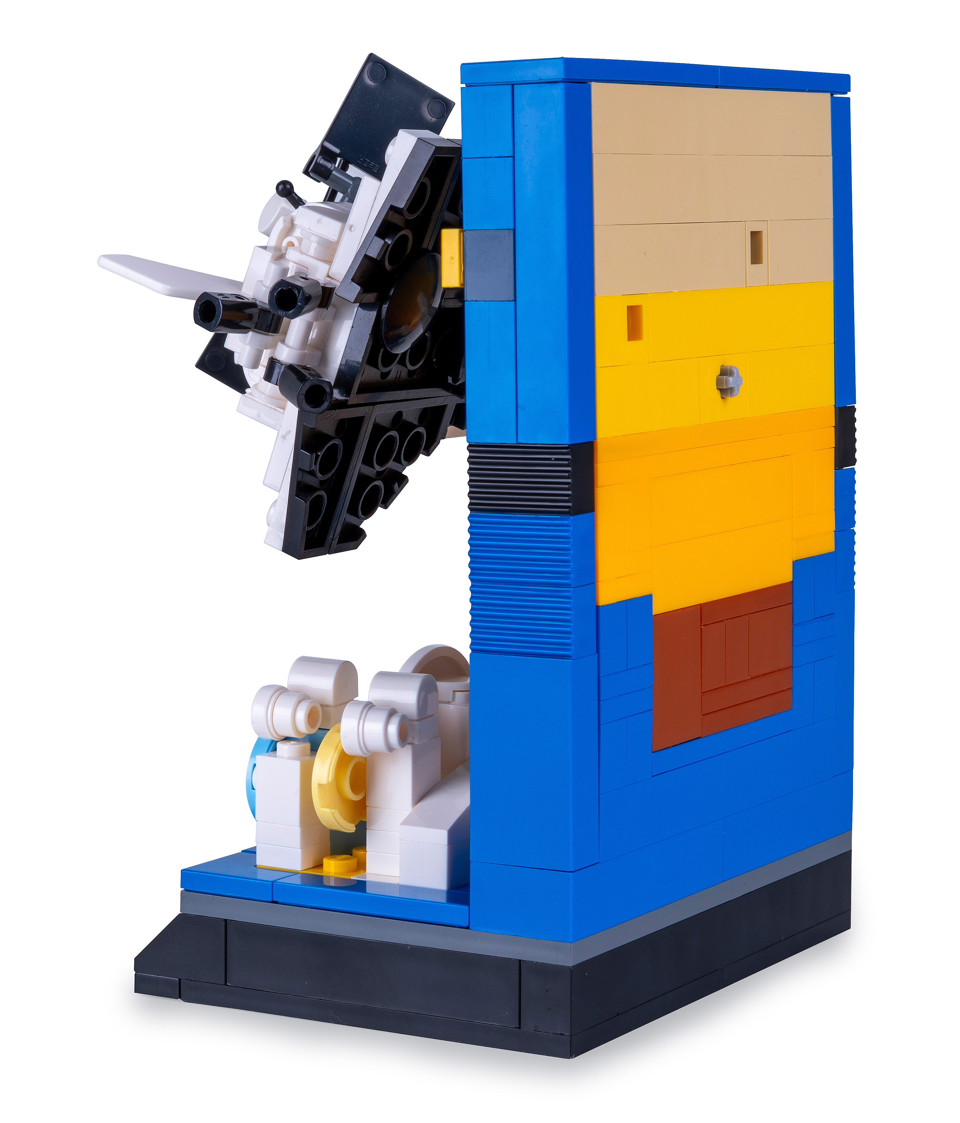 Ein Lego-Modell einer komplexen Maschine. Blaue, gelbe und weiße Blöcke bilden die Struktur mit schwarzer Basis und weißem Hintergrund.
