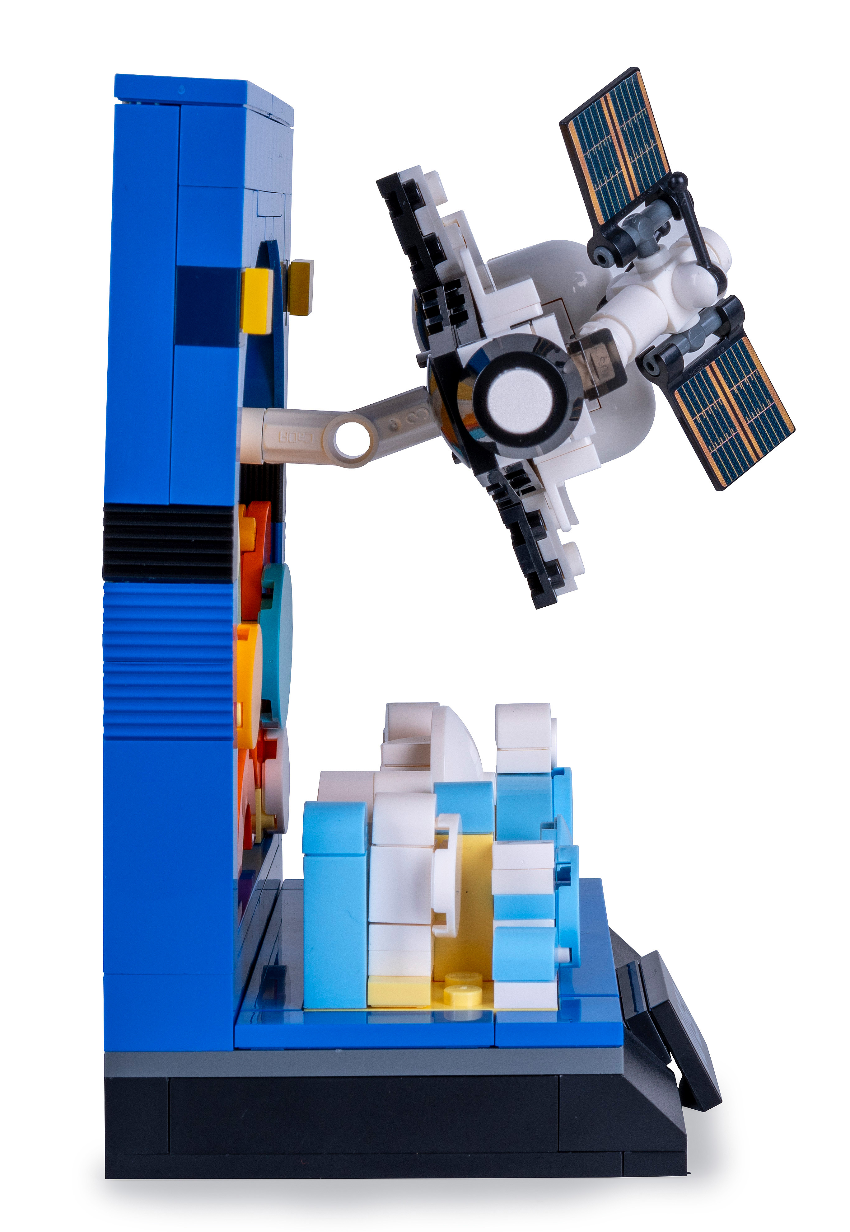 Ein Lego-Modell eines Satelliten und einer blauen Struktur mit Zahnrädern und anderen bunten Elementen.