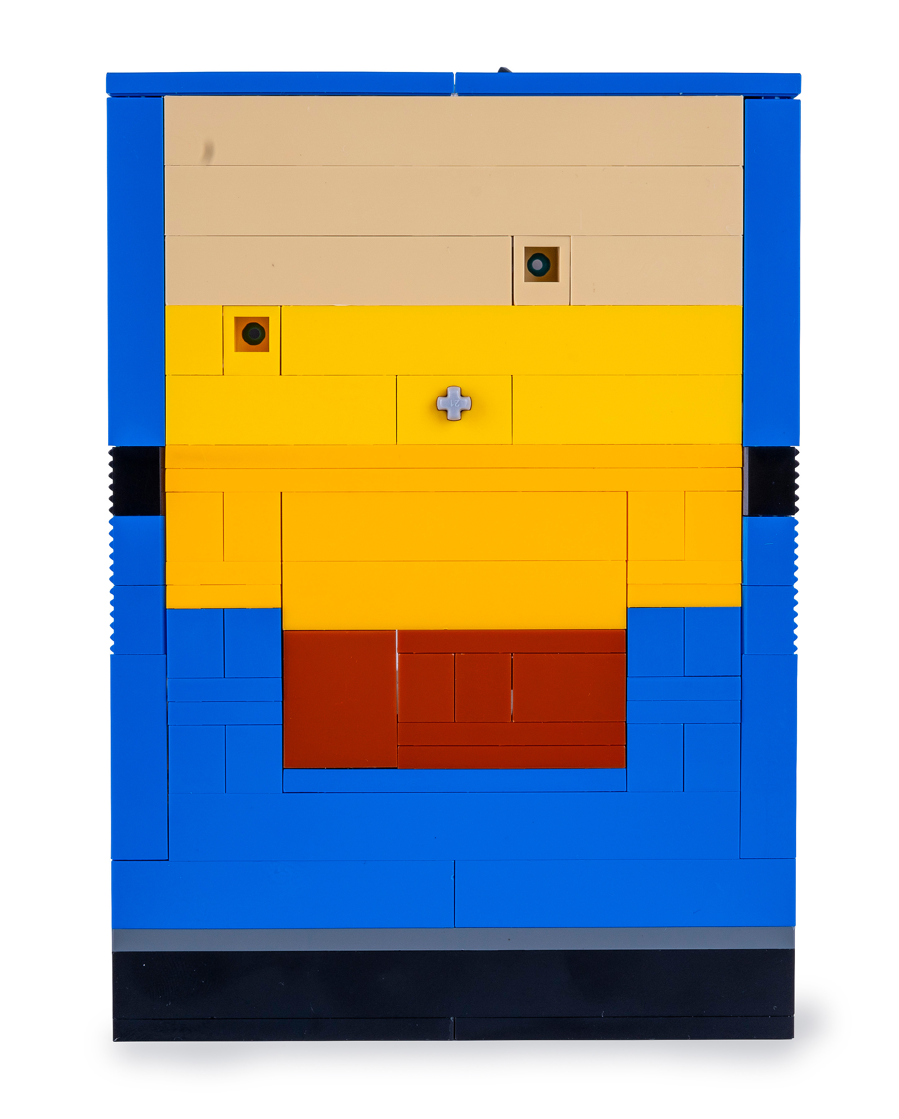Eine Lego-Struktur mit einem beigen Oberteil, einer gelben Mitte und einem blauen Rahmen. Es hat kleine grüne Kreise und ein graues Kreuz.