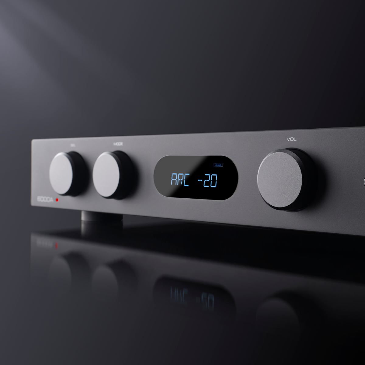 Een donkergrijze audioversterker met knoppen en een digitaal display met 'ARC -20'. Het oppervlak reflecteert het apparaat.
