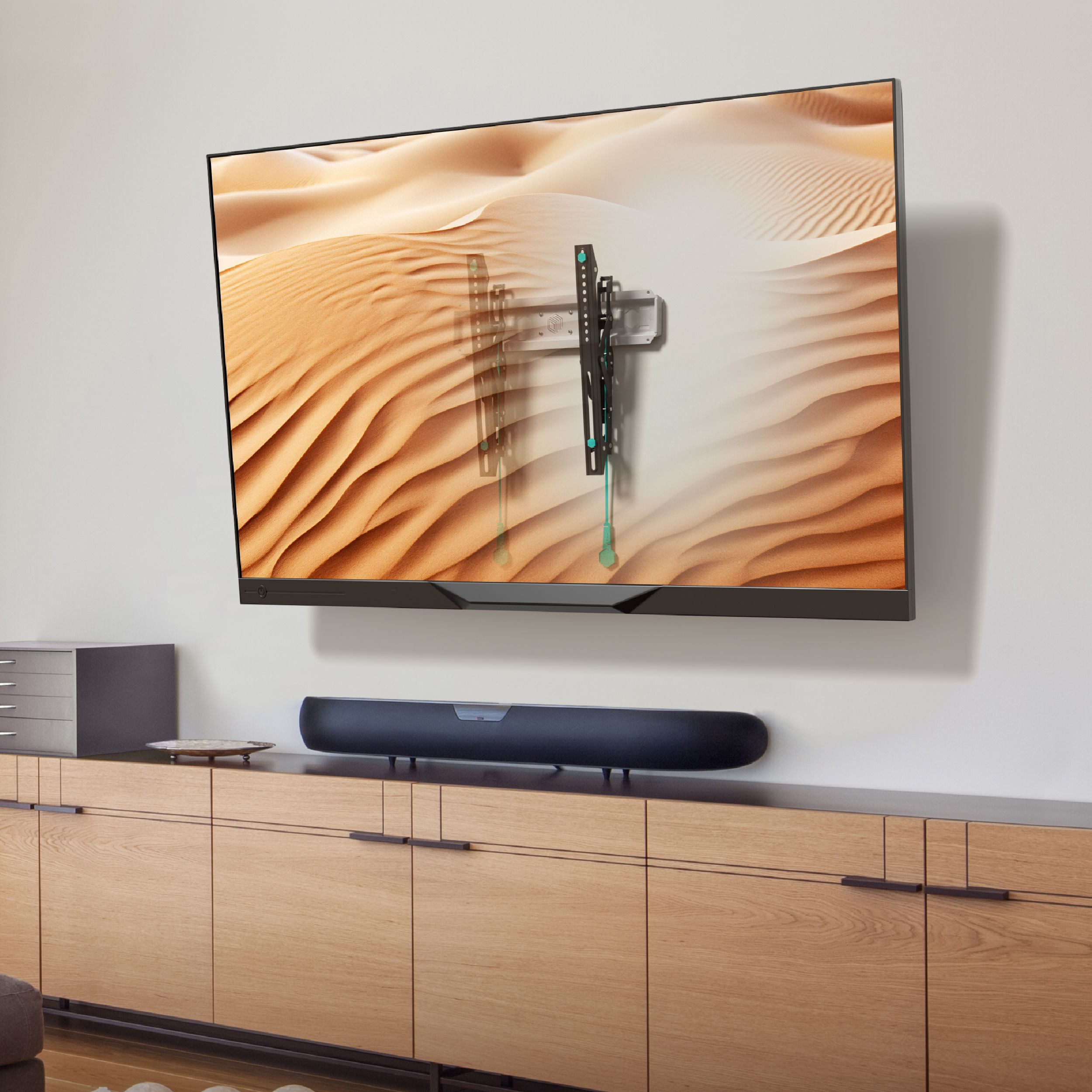 Telewizor zamontowany na ścianie wyświetla scenę pustynną. Poniżej soundbar na drewnianej szafce.
