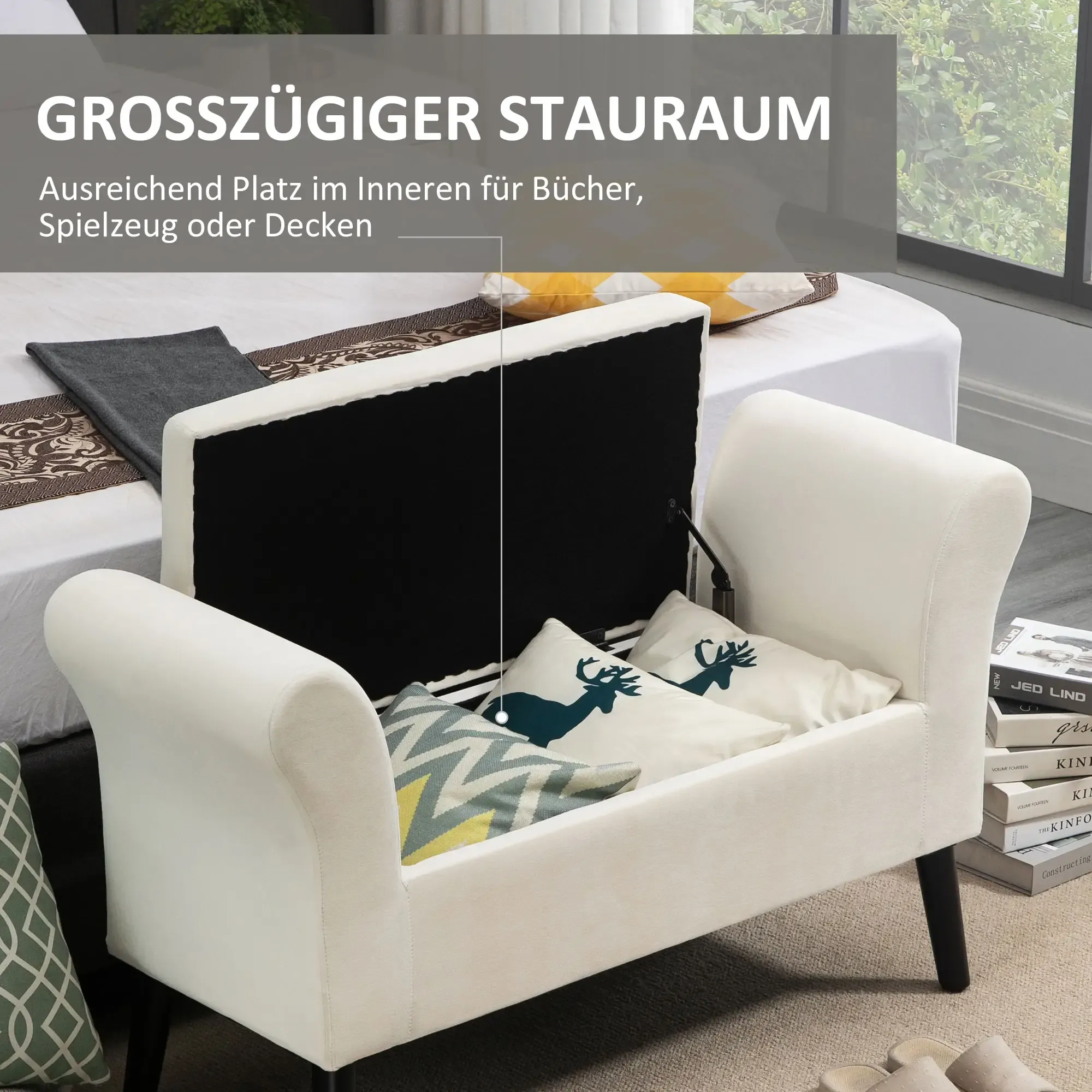 Weiße Stauraumbank mit Kissen. Im Hintergrund ein Bett, neben einem Fenster. Bücher sind rechts gestapelt.