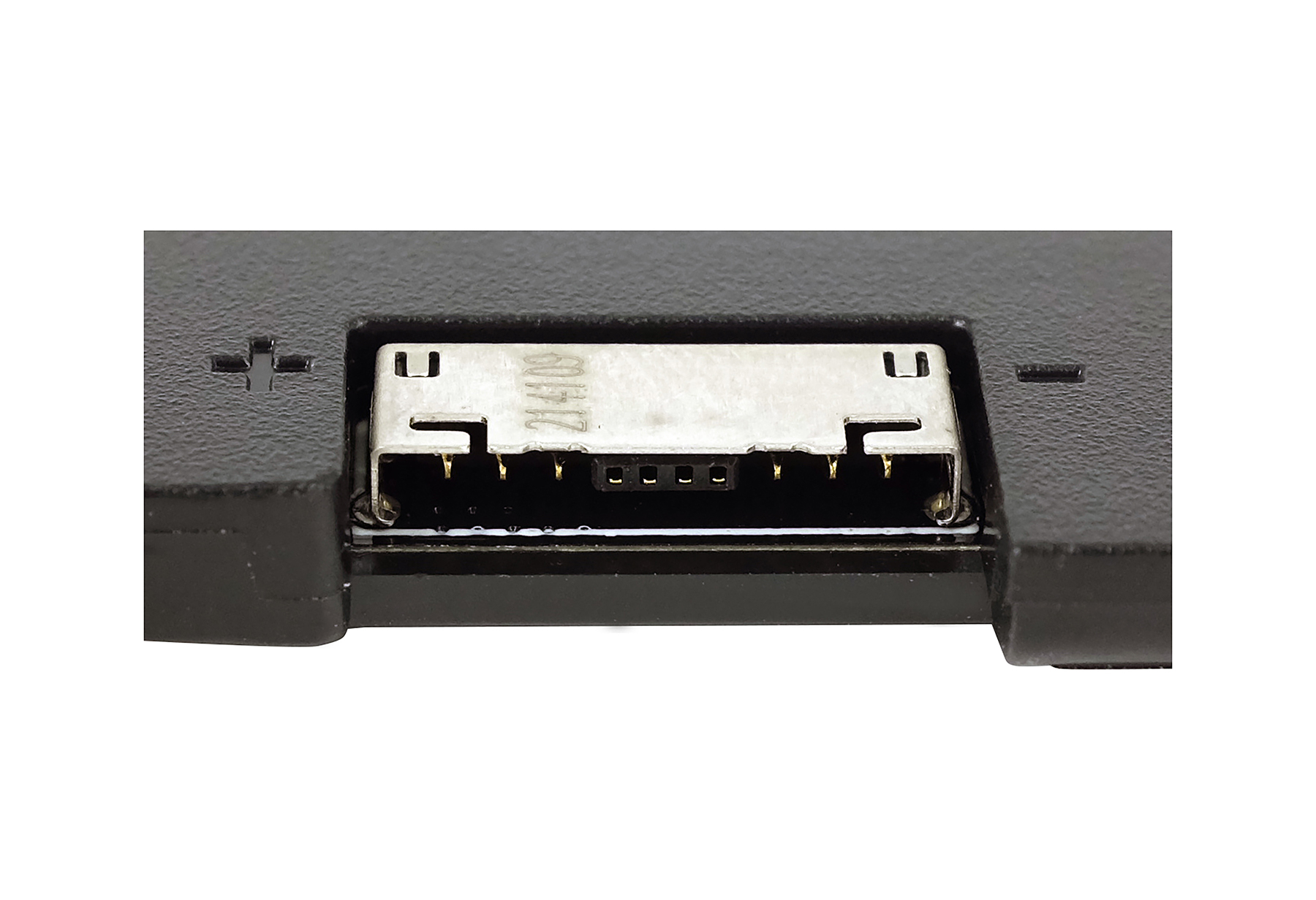 Primo piano di un dispositivo nero con una porta USB. Porta metallica argentata con numeri e pin dorati. Sono visibili segni più e meno.