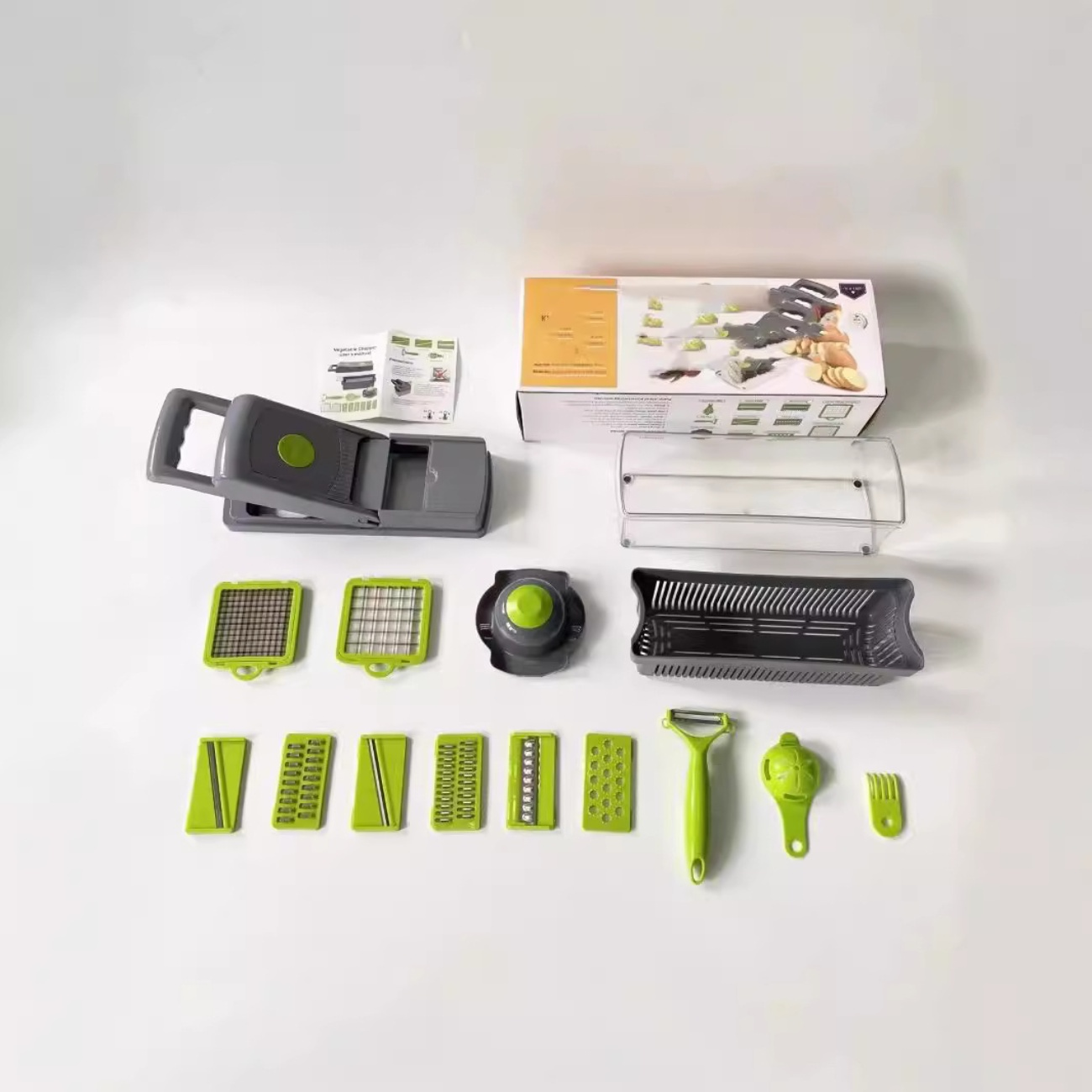 Ein neues Gemüseschneiderset. Enthält Chopper, Klingen, Behälter, Schäler und andere Werkzeuge, alles auf einer weißen Oberfläche angeordnet.