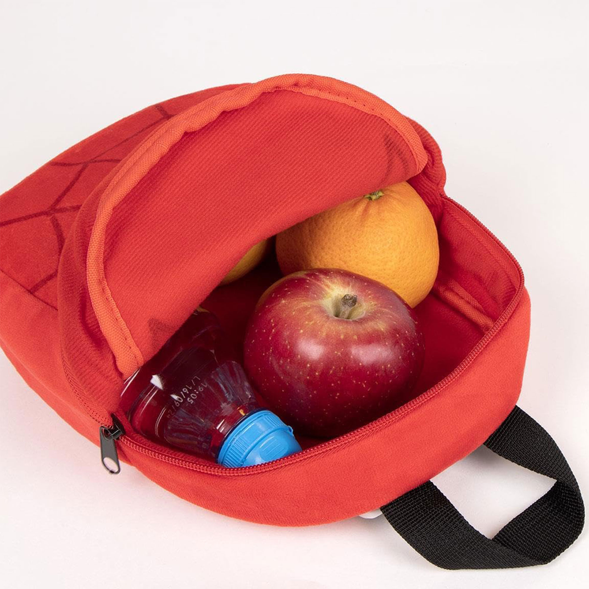 Mochila roja abierta con fruta y bebida. Una manzana, naranja y botella con tapa azul dentro. Asa negra.