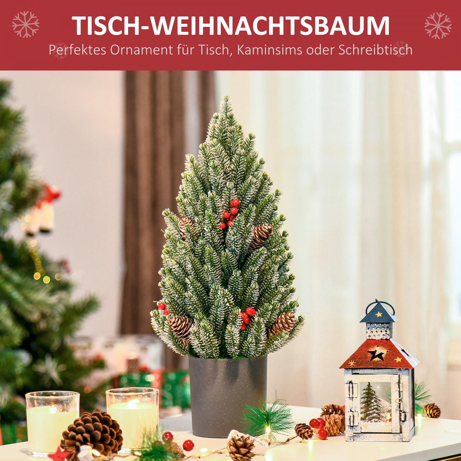 Ein kleiner Weihnachtsbaum in einem Topf auf einem Tisch, mit Kerzen, Tannenzapfen und einer Laterne. Ein größerer Weihnachtsbaum im Hintergrund.