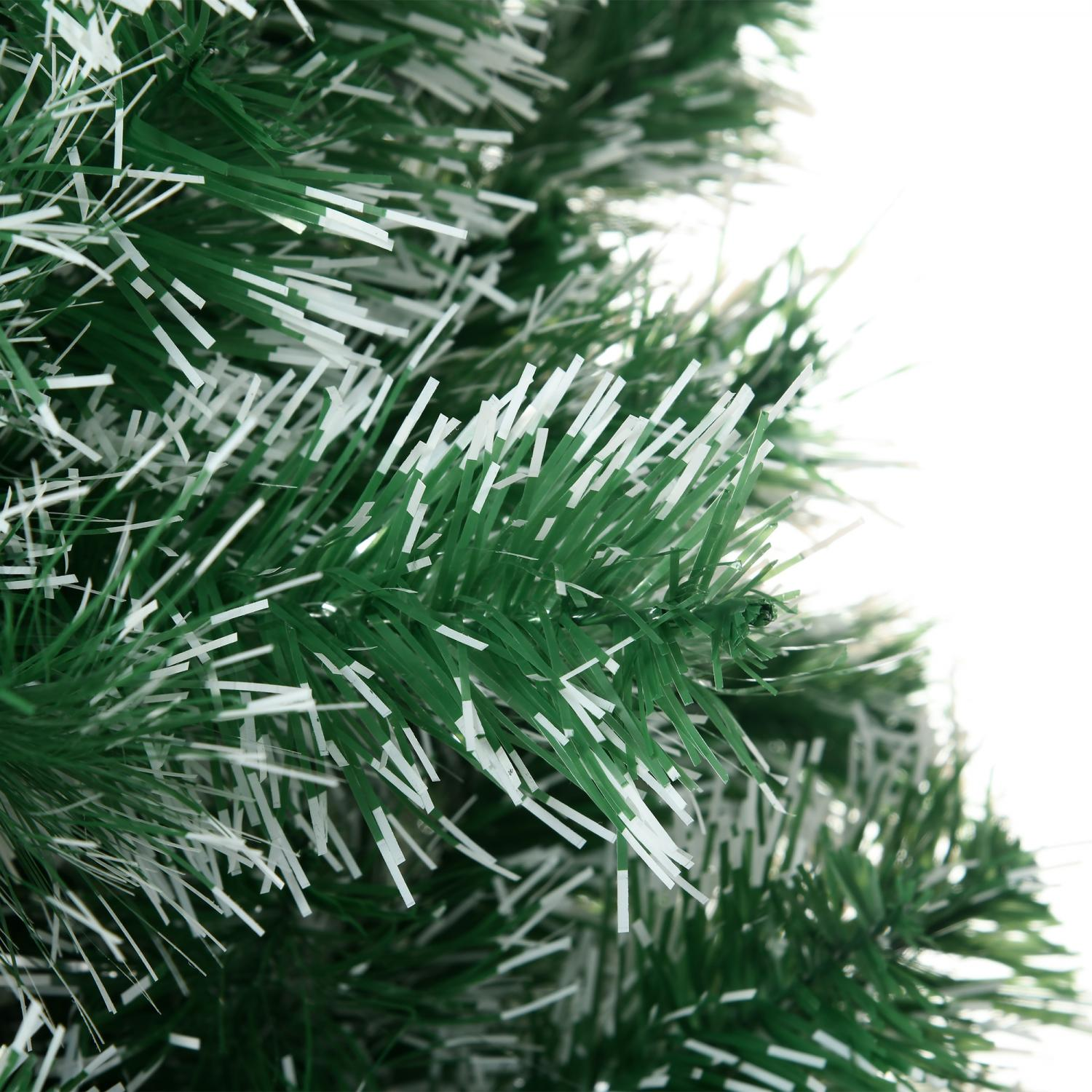 Nahaufnahme eines grünen Weihnachtsbaums mit weißen Akzenten. Äste sind sichtbar, mit weißem Hintergrund.