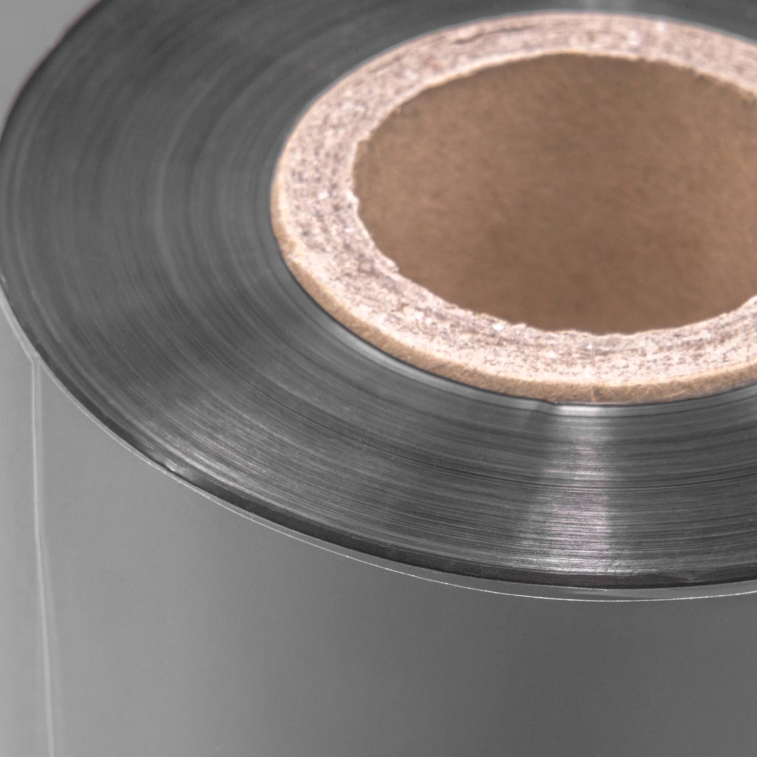 Eine Rolle grauen Materials mit einem braunen Pappkern. Die Rolle ist eng gewickelt, Schichten sichtbar.