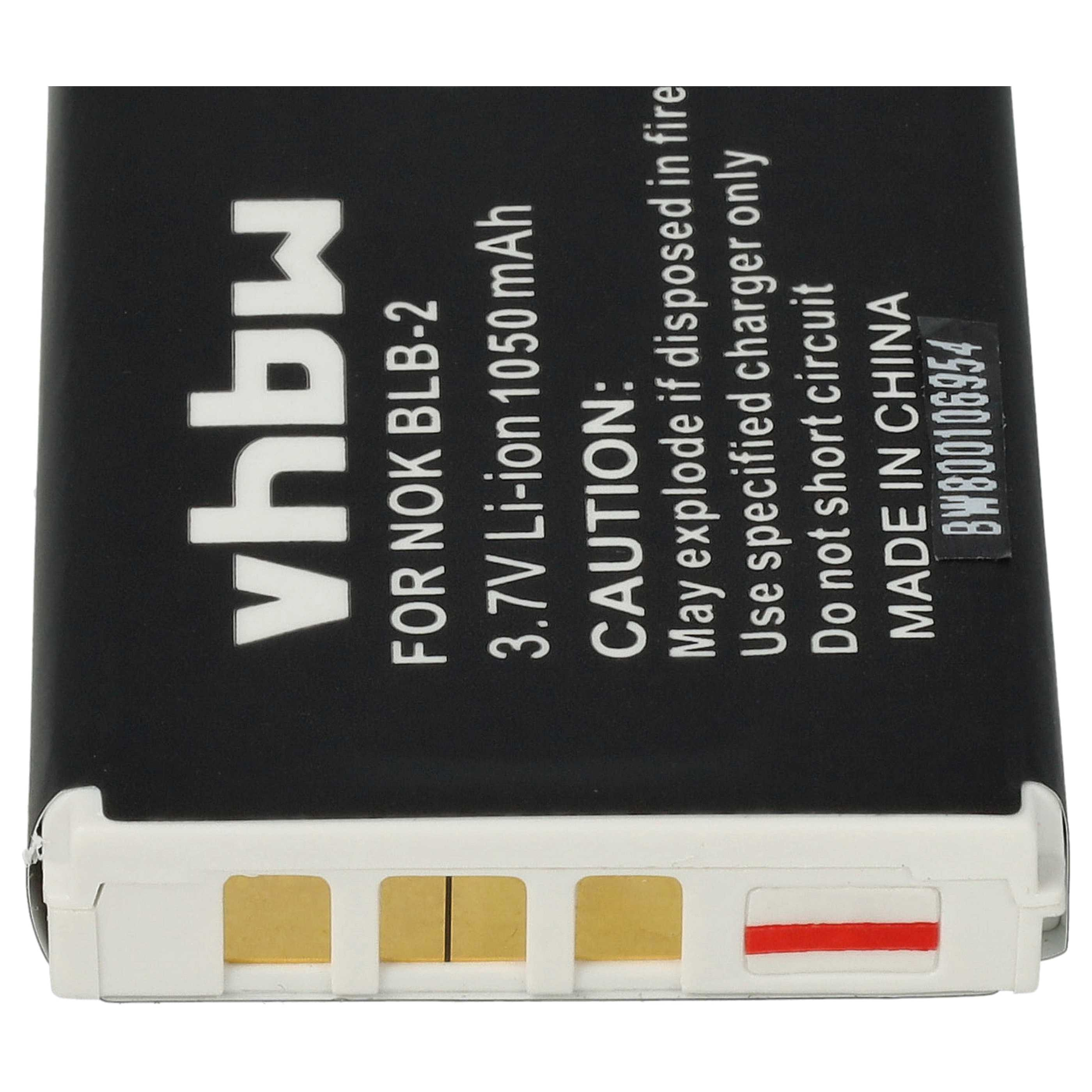 Schwarzer Akku mit weißem Text: 'vhbw', 'NOK BLB-2' und Warnhinweisen. Unten befinden sich goldene und rote Kontakte.