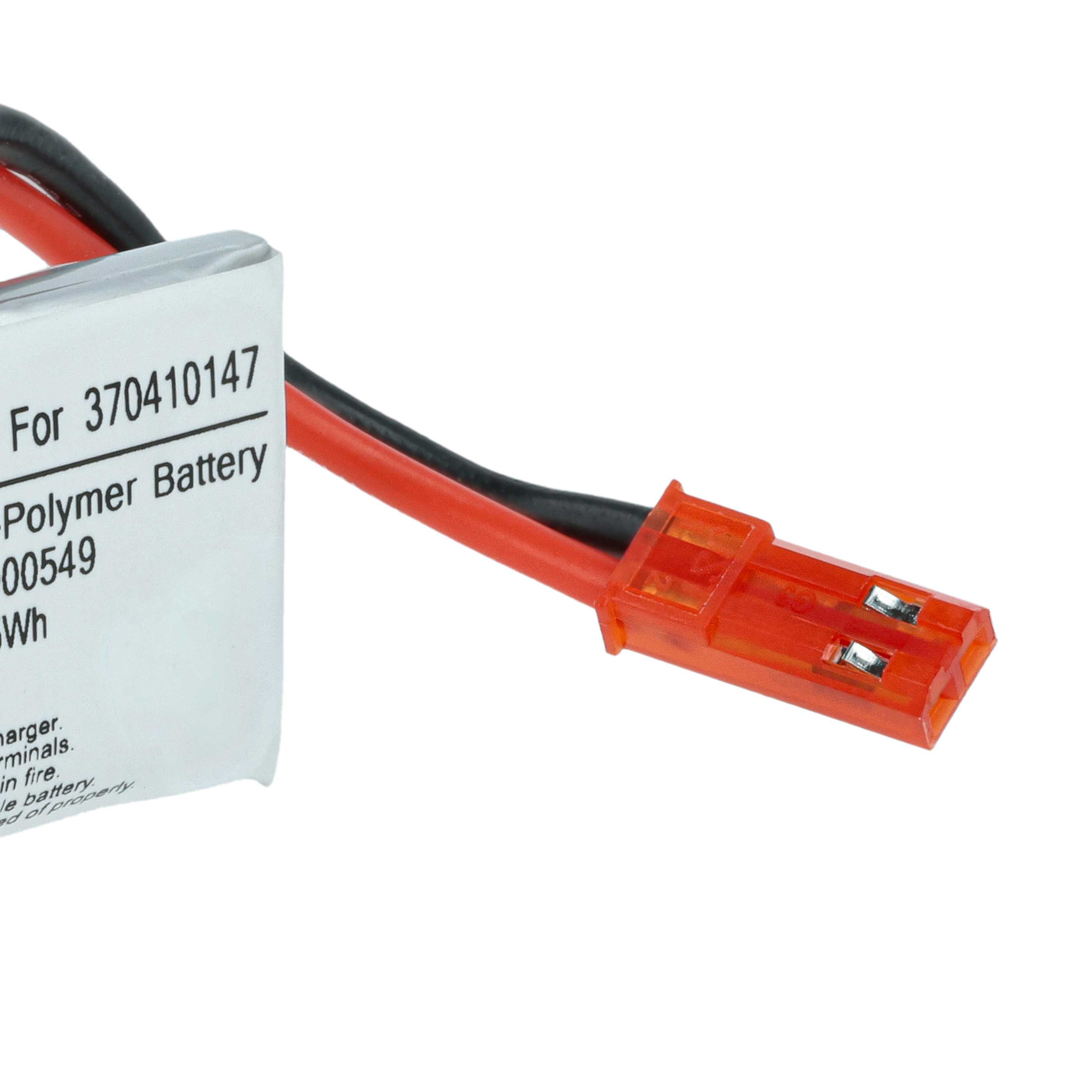 Nahaufnahme eines weißen Etiketts auf einer Batterie mit roten und schwarzen Drähten, die in einem orangefarbenen Stecker enden, isoliert auf Weiß.