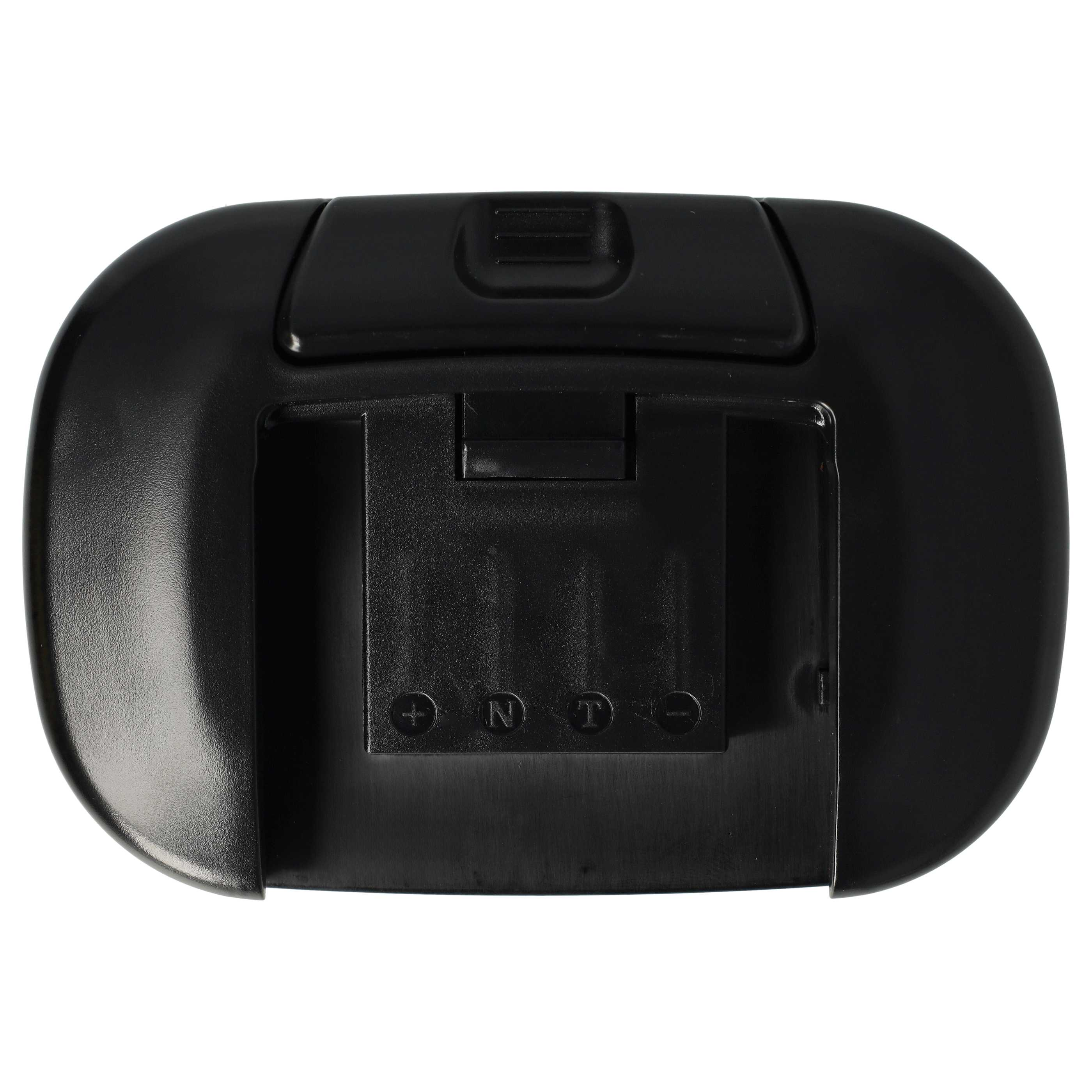 Ein schwarzes Plastikgerät, möglicherweise ein Batterieladegerät. Es hat einen Schlitz mit Markierungen und eine Aussparung oben.