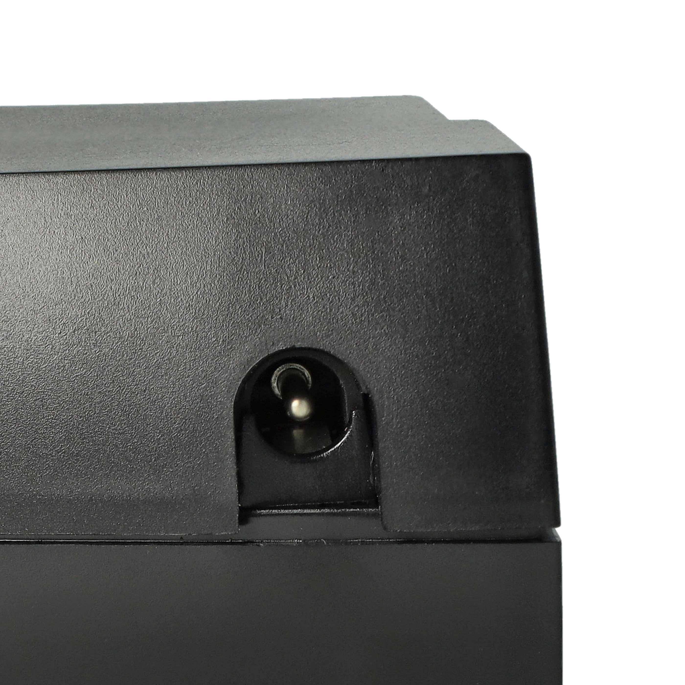 Nahaufnahme eines schwarzen elektronischen Geräts mit rundem Stromeingang. Der Hintergrund ist ein weißer Farbverlauf.
