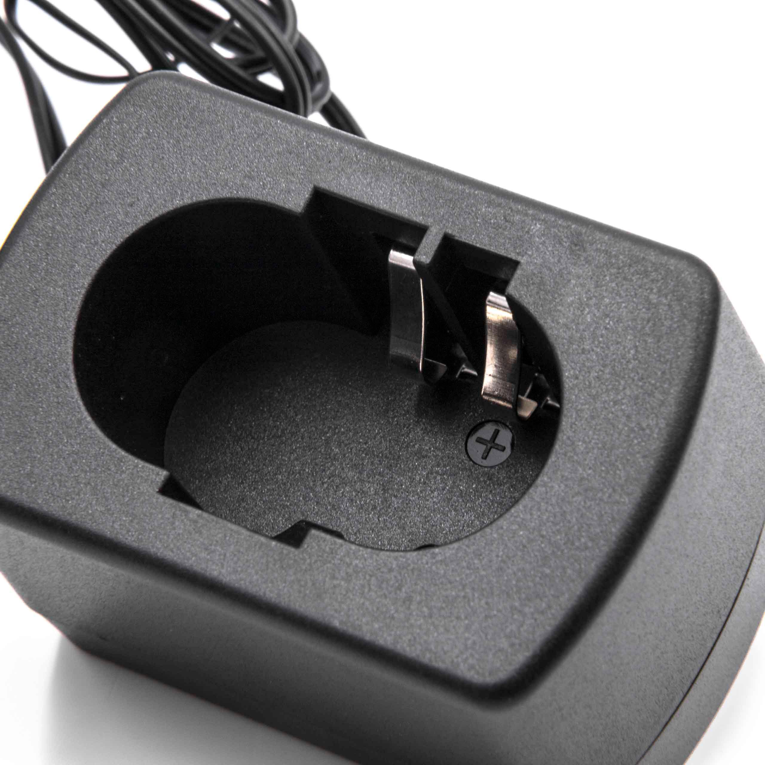 Ein schwarzes Batterieladegerät mit einer kreisförmigen Aussparung und Metallkontakten. Ein schwarzes Kabel ist sichtbar.
