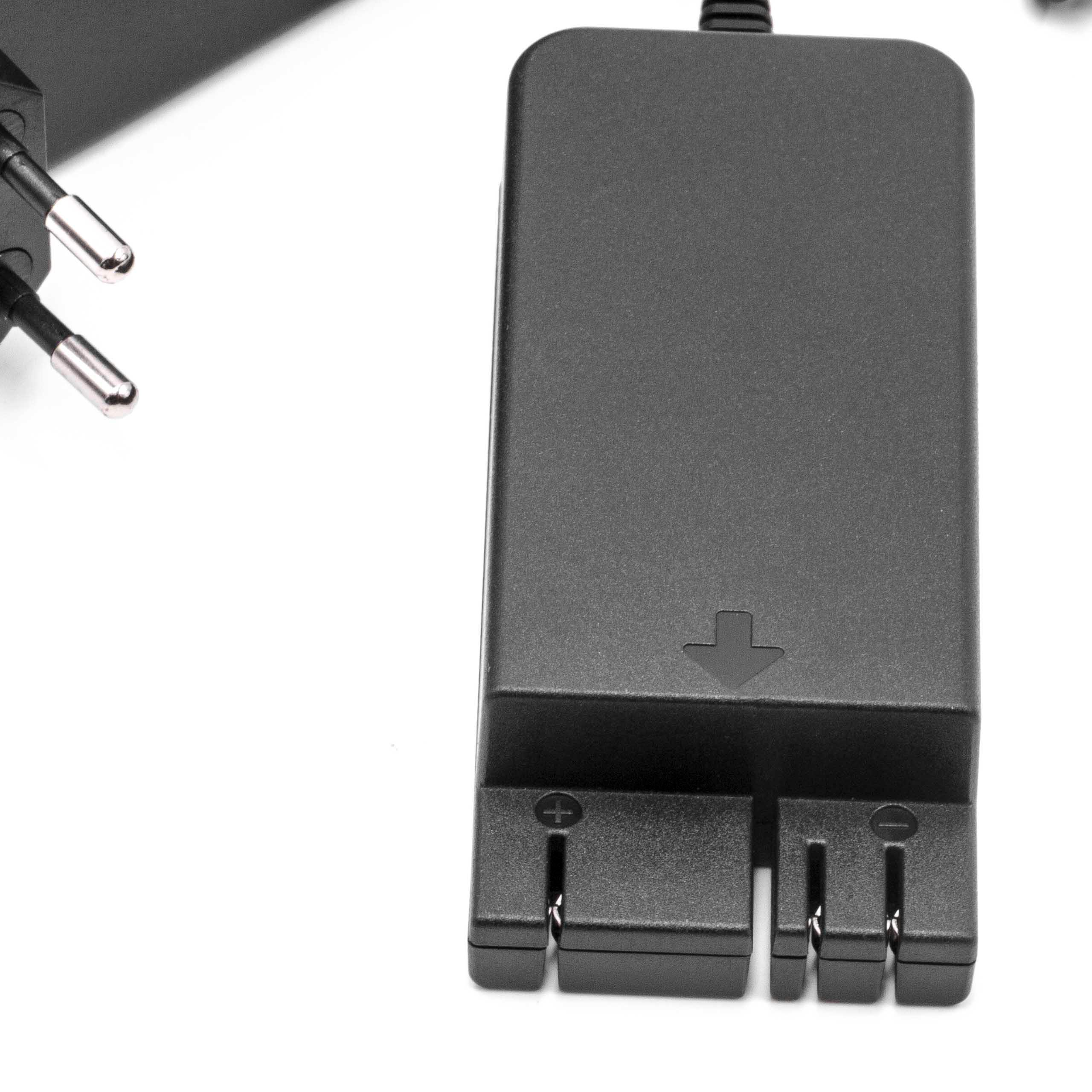 Schwarzes Netzteil mit Stecker. Der Adapter hat einen Pfeil und Plus/Minus-Symbole. Weißer Hintergrund.