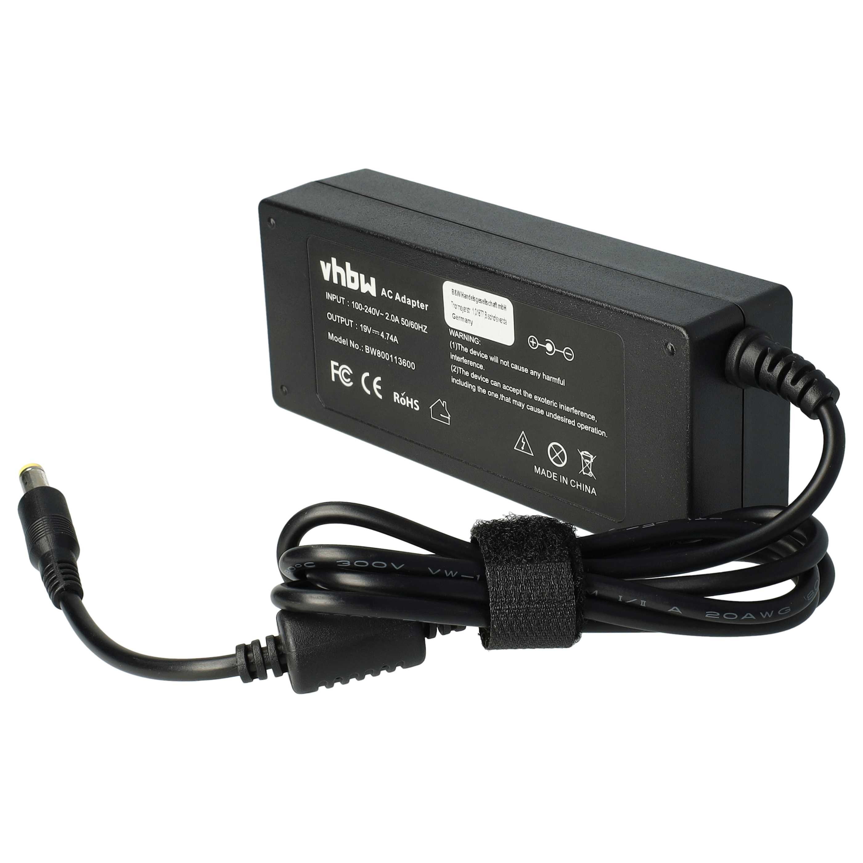 Schwarzer AC-Adapter mit Kabel, Textetikett und Stecker. Das Etikett hat Text und Symbole.
