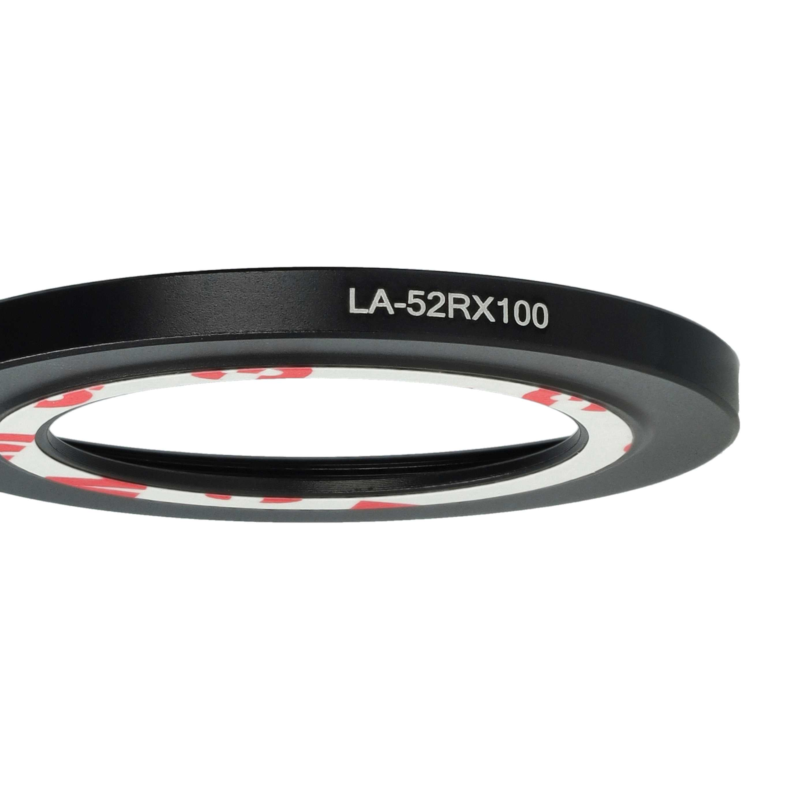Ein schwarzer Objektivadapterring mit weißen und roten Akzenten. Text 'LA-52RX100' ist sichtbar. Der Hintergrund ist schlicht weiß.