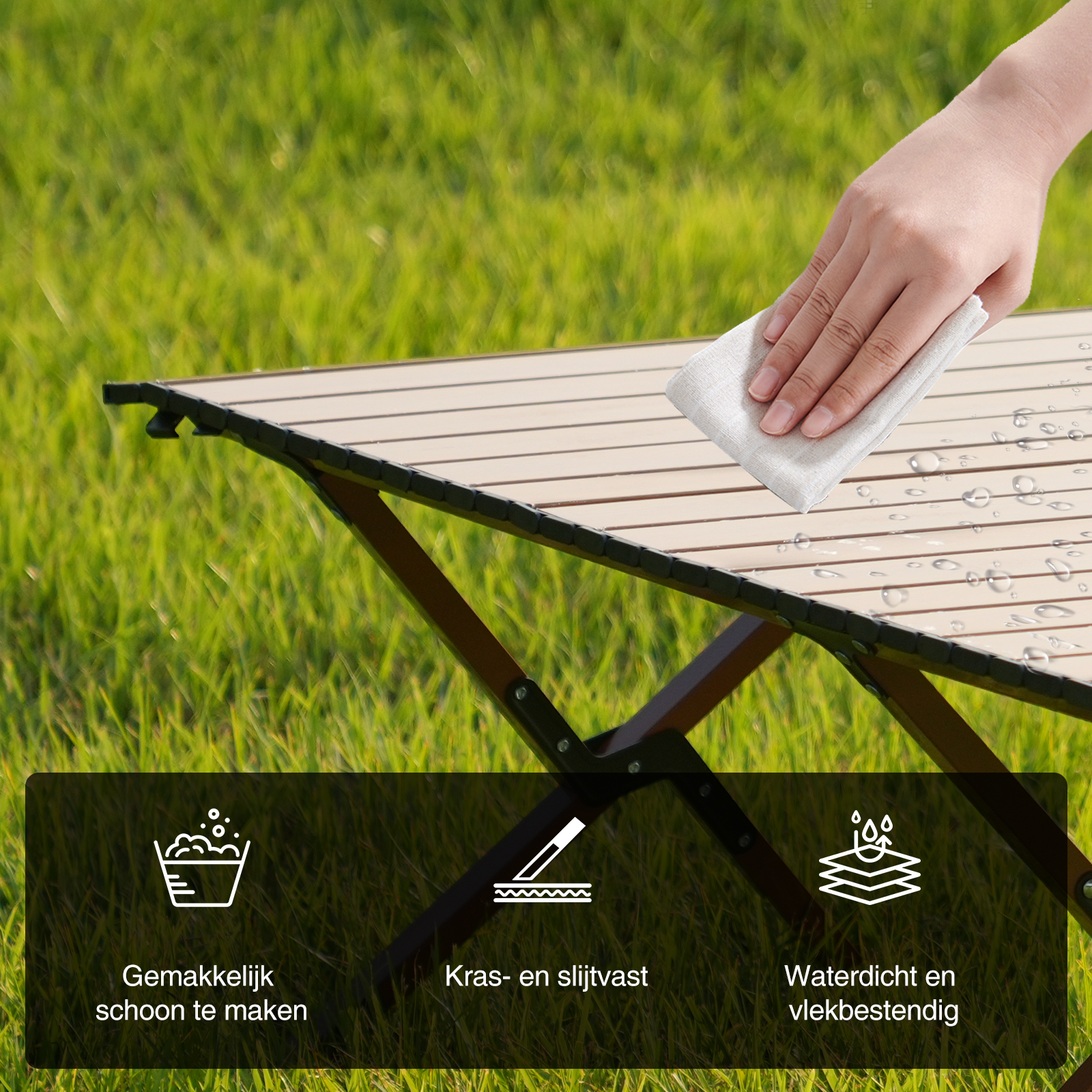Een hand veegt een houten campingtafel af met een doek. De tafel staat op groen gras. Kenmerken zijn gemakkelijk schoon te maken, krasbestendig en waterdicht.