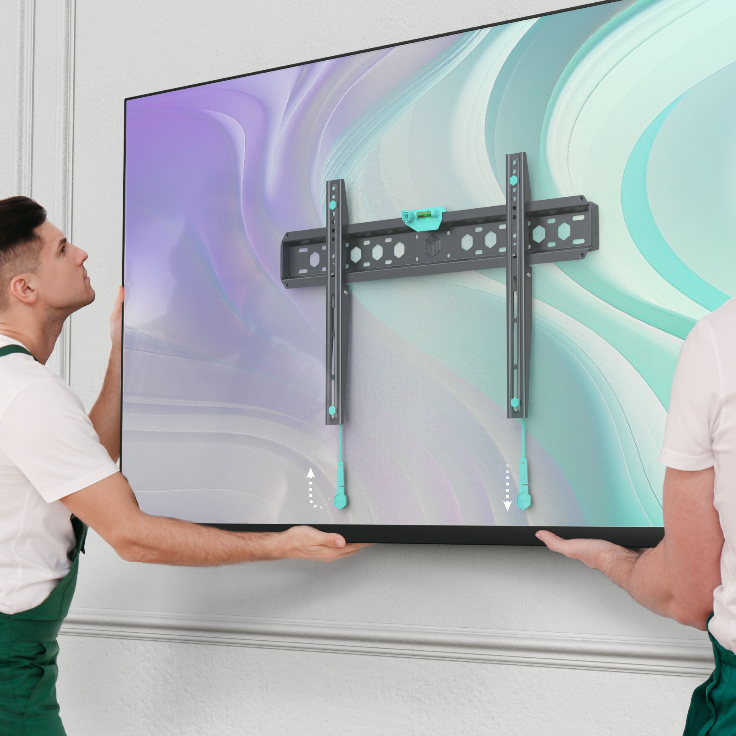 Dwóch mężczyzn trzyma telewizor z uchwytem ściennym. Ściana ma dekoracyjną listwę. Telewizor wyświetla kolorowy abstrakcyjny wzór.