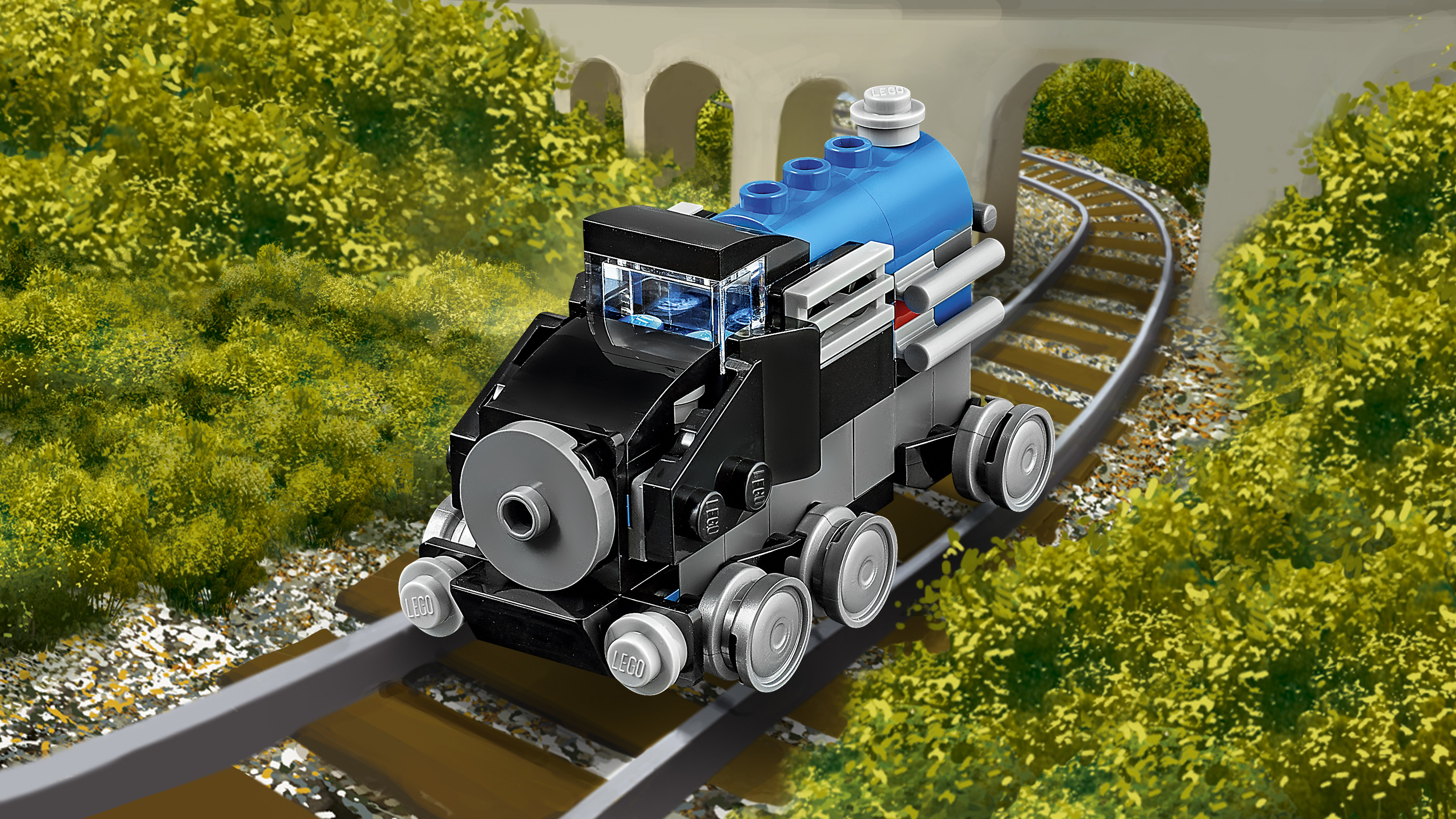Un trenino Lego giocattolo su un binario. Il treno è nero e blu. Il binario è su un terrapieno, che passa sotto un arco.