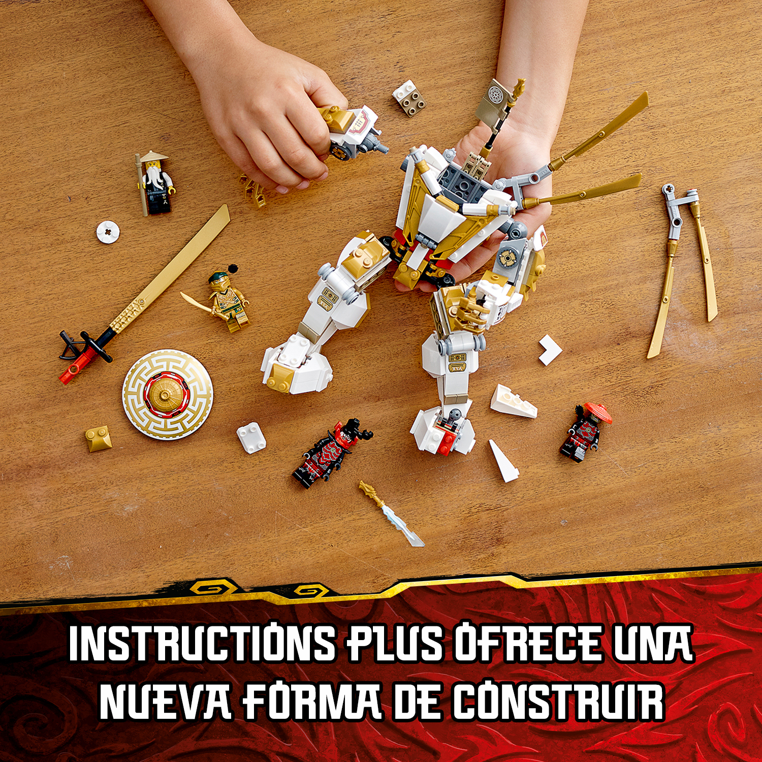 Ręce dziecka składające biało-złotego mecha Lego z miniaturowymi figurkami i bronią na drewnianym stole.