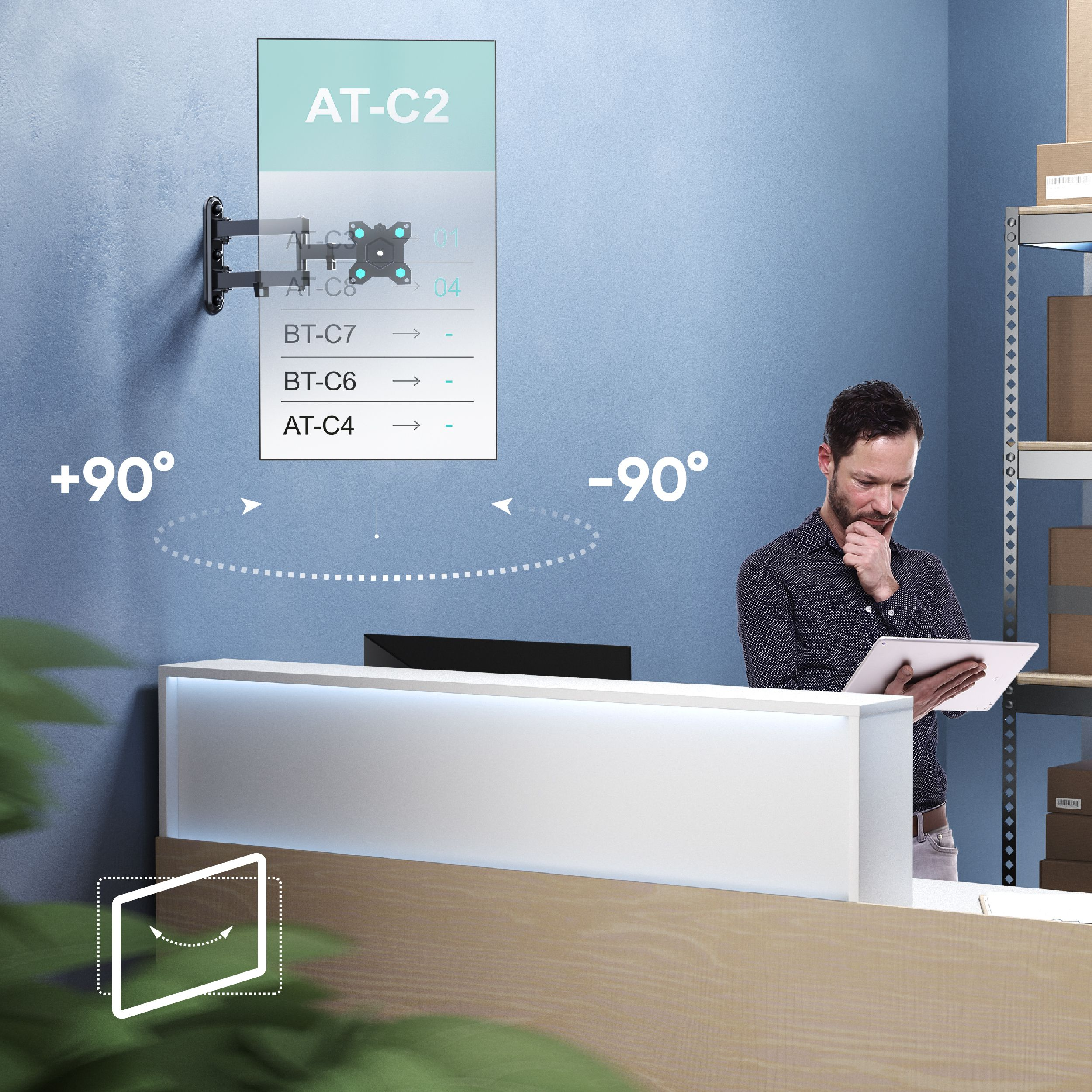 Mężczyzna z tabletem stoi blisko lady. Uchwyt ścienny do telewizora jest po lewej stronie. Na ścianie znajduje się lista.