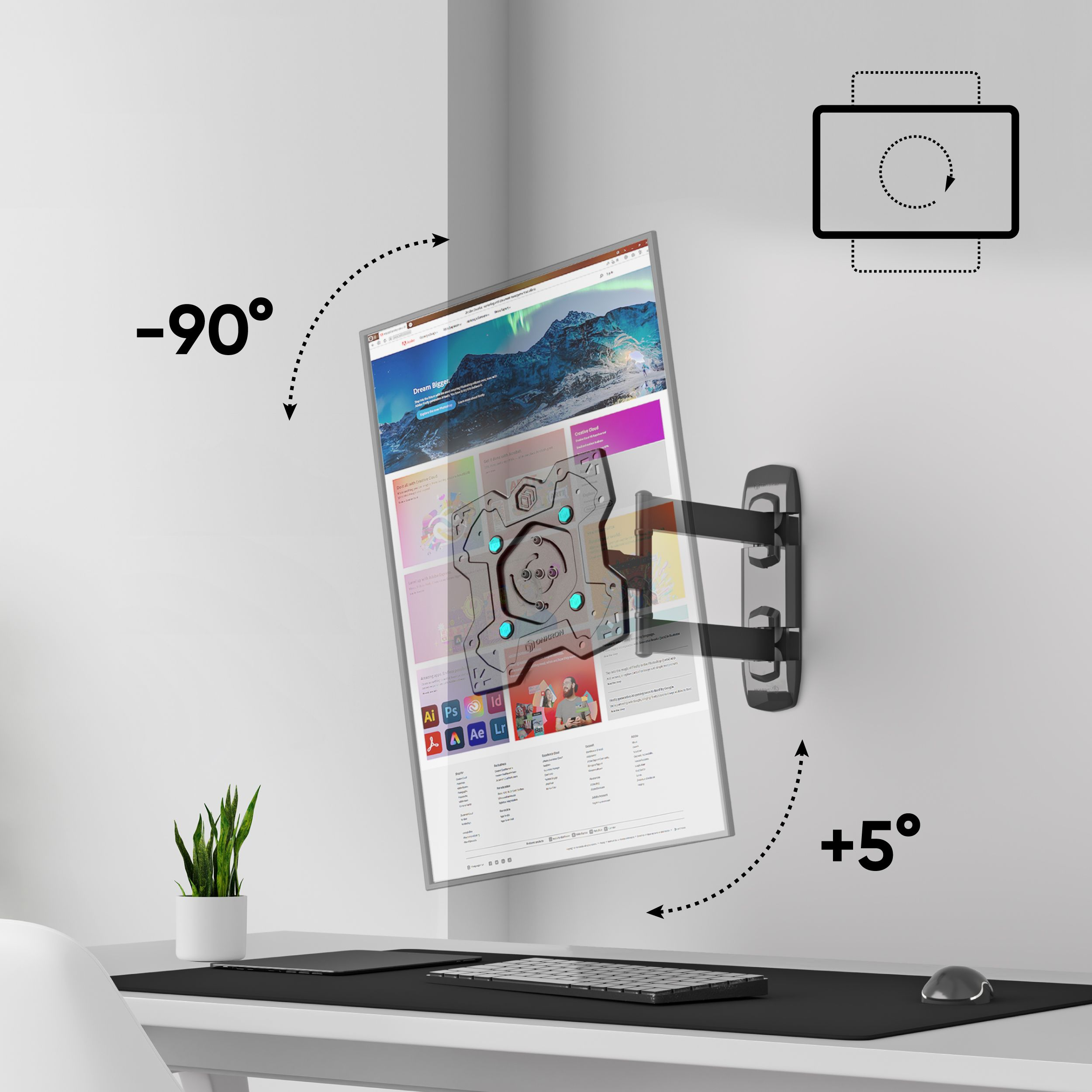 Monitor na obrotowym ramieniu jest zamontowany na białej ścianie. Z przodu biurko z klawiaturą, myszą i rośliną.