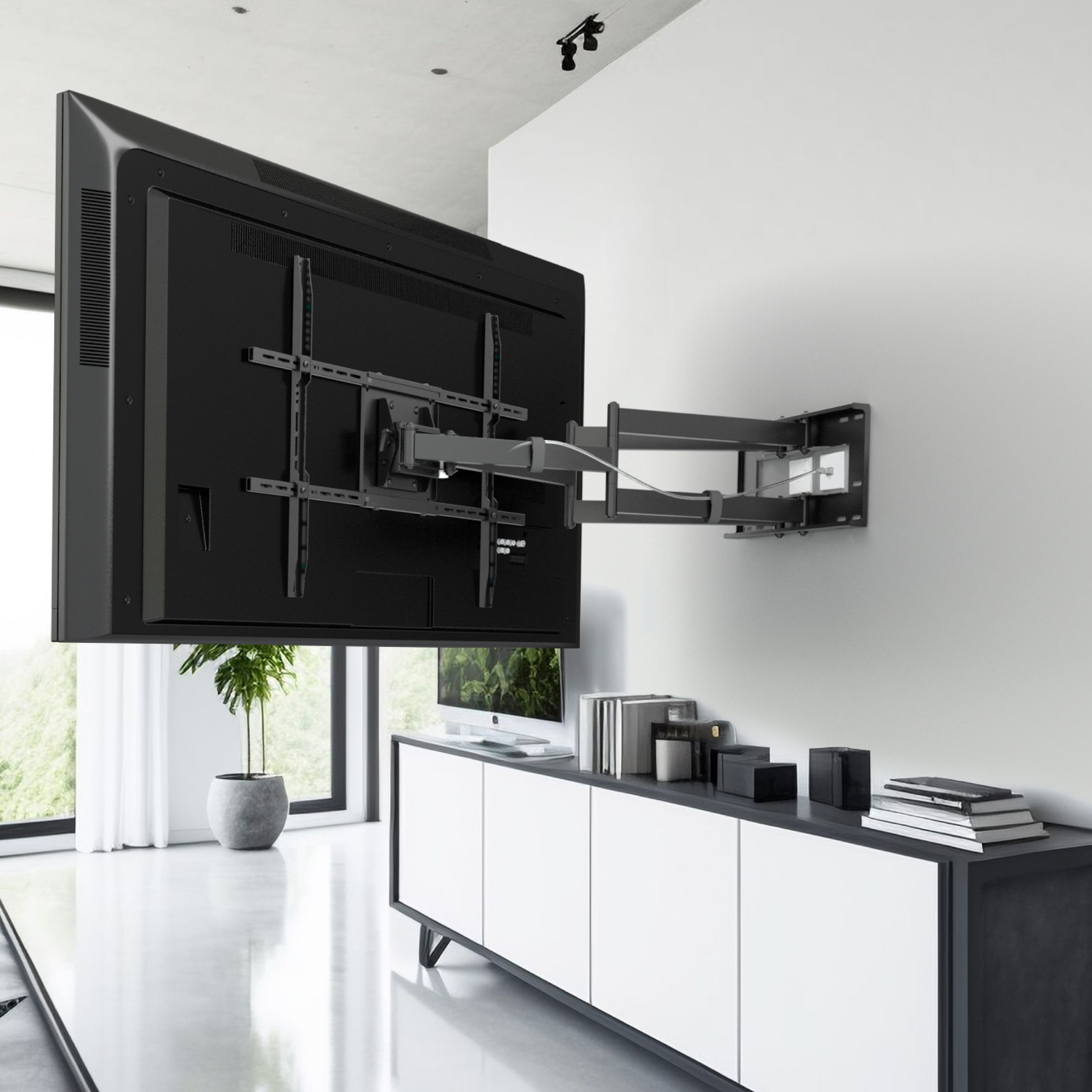 Duży czarny telewizor jest zamontowany na ścianie. Poniżej szafka z książkami i dekoracjami. Roślina na podłodze.