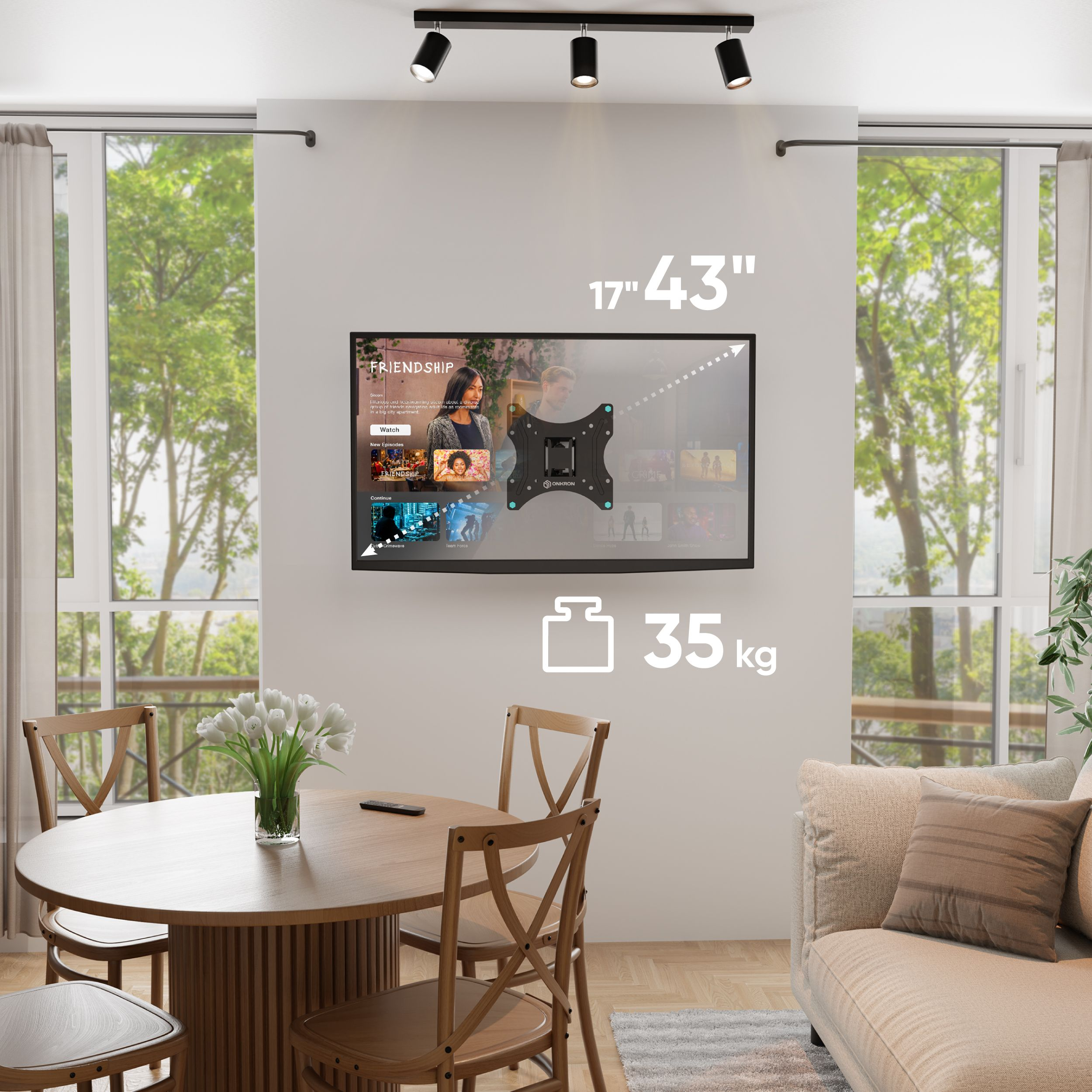 Salon z telewizorem na ścianie, okrągłym stołem z krzesłami i beżową sofą. Okna w tle.