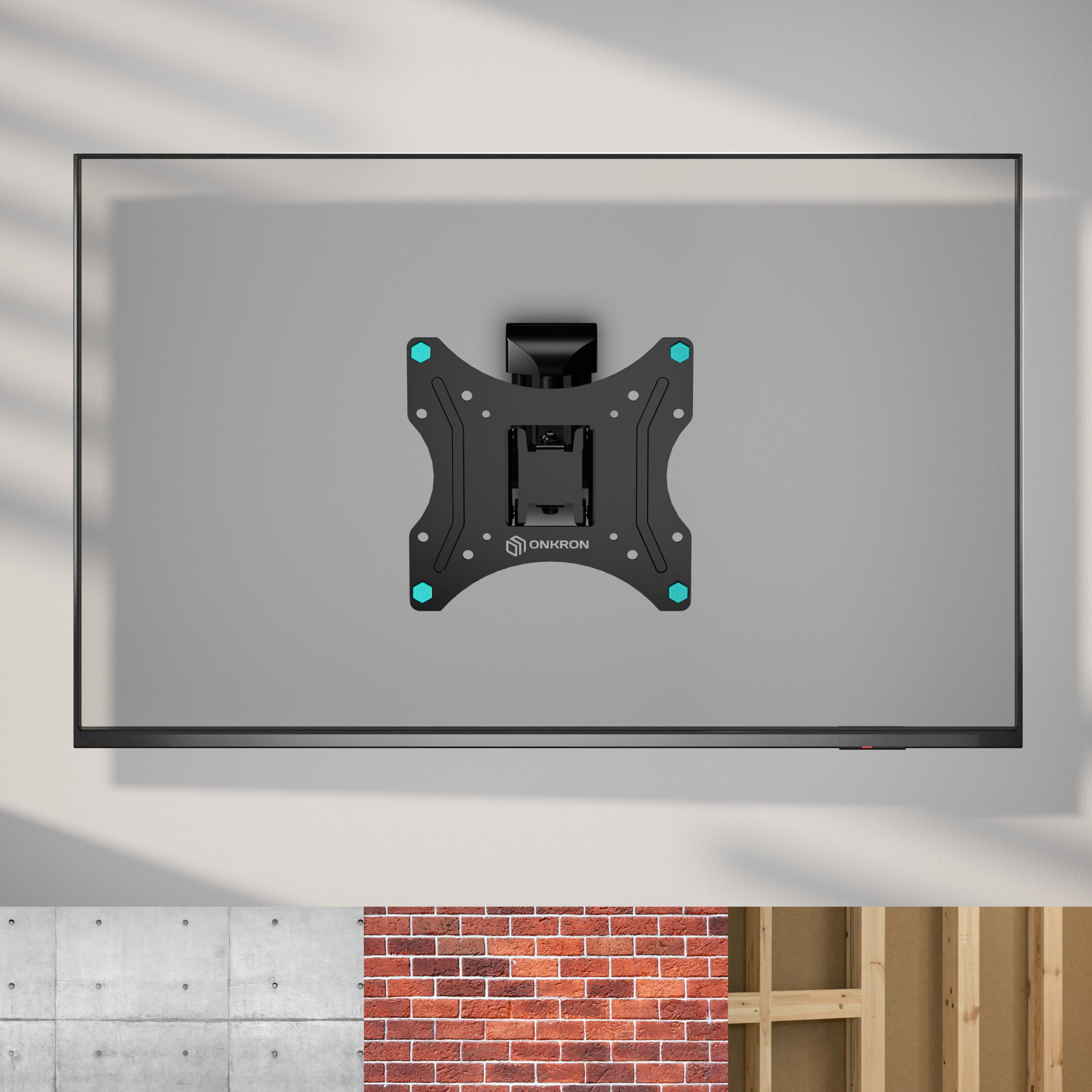 Uchwyt TV na szarej ścianie. Uchwyt jest czarny z niebieskimi akcentami. Poniżej próbki betonu, cegły i drewna.