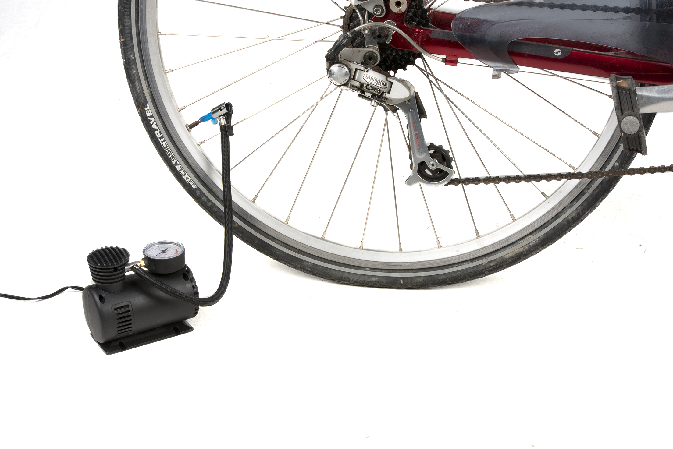 Una ruota di bicicletta con una pompa d'aria collegata. Il pneumatico viene gonfiato. La ruota, le parti della bici e la pompa sono isolate su sfondo bianco.