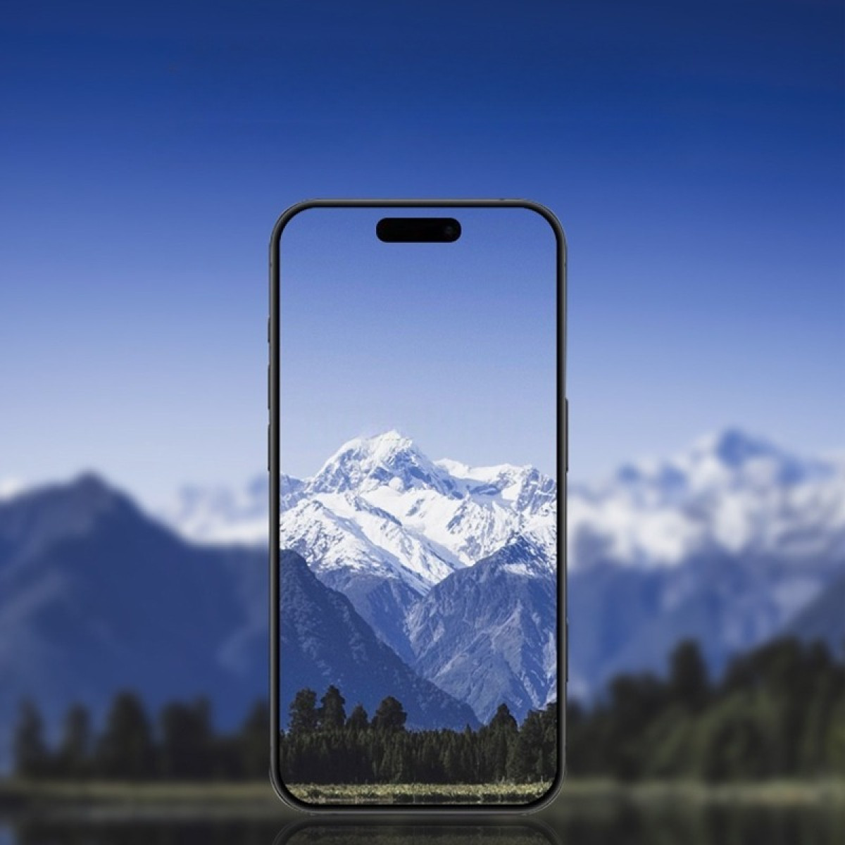 Uno smartphone mostra un paesaggio montano con cime innevate, alberi e un lago, il tutto sotto un cielo blu brillante.