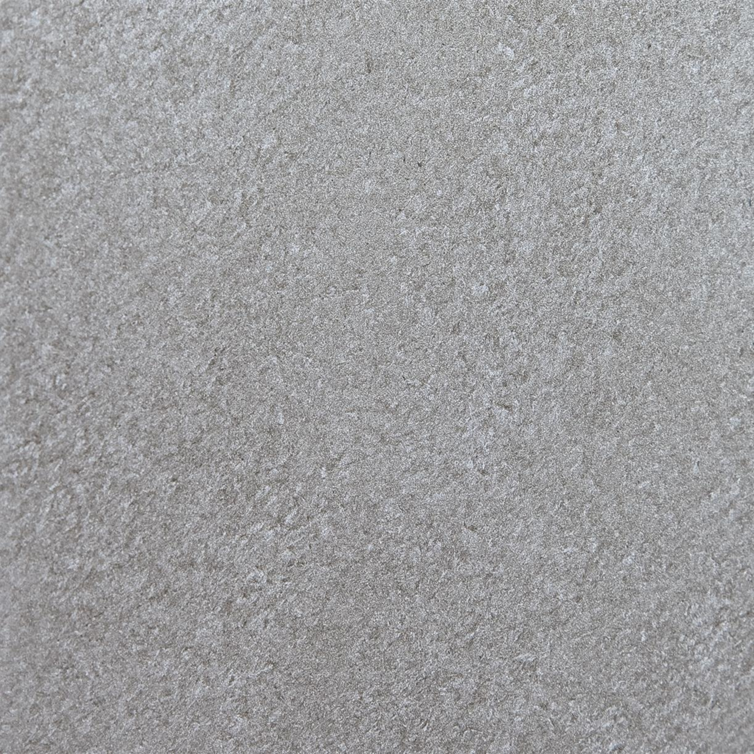 Nahaufnahme einer strukturierten, grauen Oberfläche. Die Textur ist rau und uneben, mit kleinen, körnigen Details.