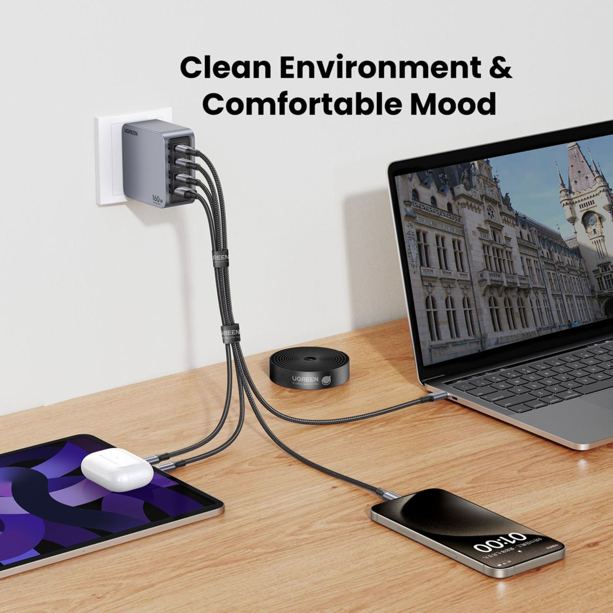 Stacja ładująca zasila tablet, telefon i laptopa. Malowniczy budynek znajduje się na ekranie laptopa. Scena rozgrywa się na drewnianej powierzchni.