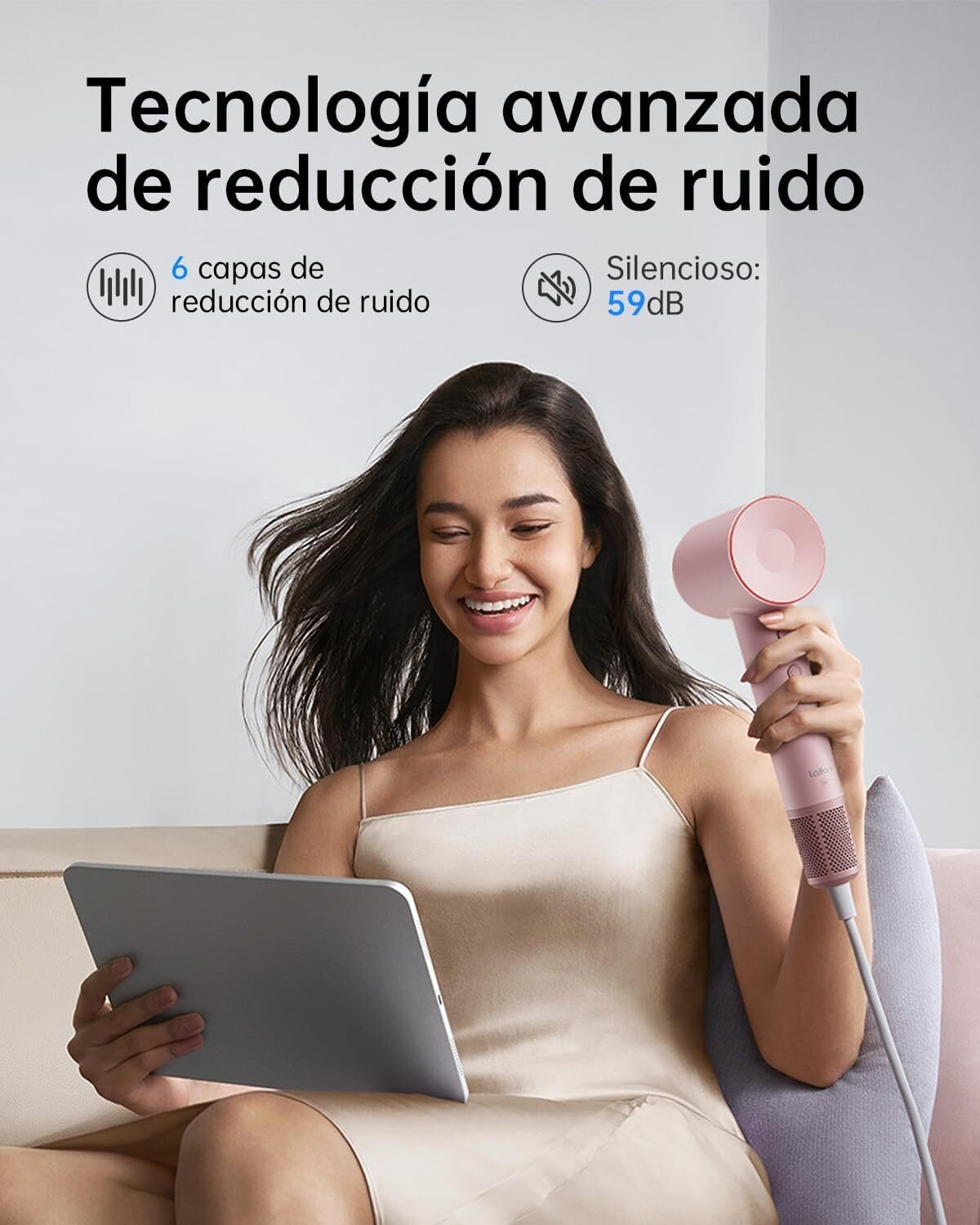 Una donna sorride, tiene un tablet e un asciugacapelli rosa. Il testo in alto dice "tecnologia avanzata di riduzione del rumore".