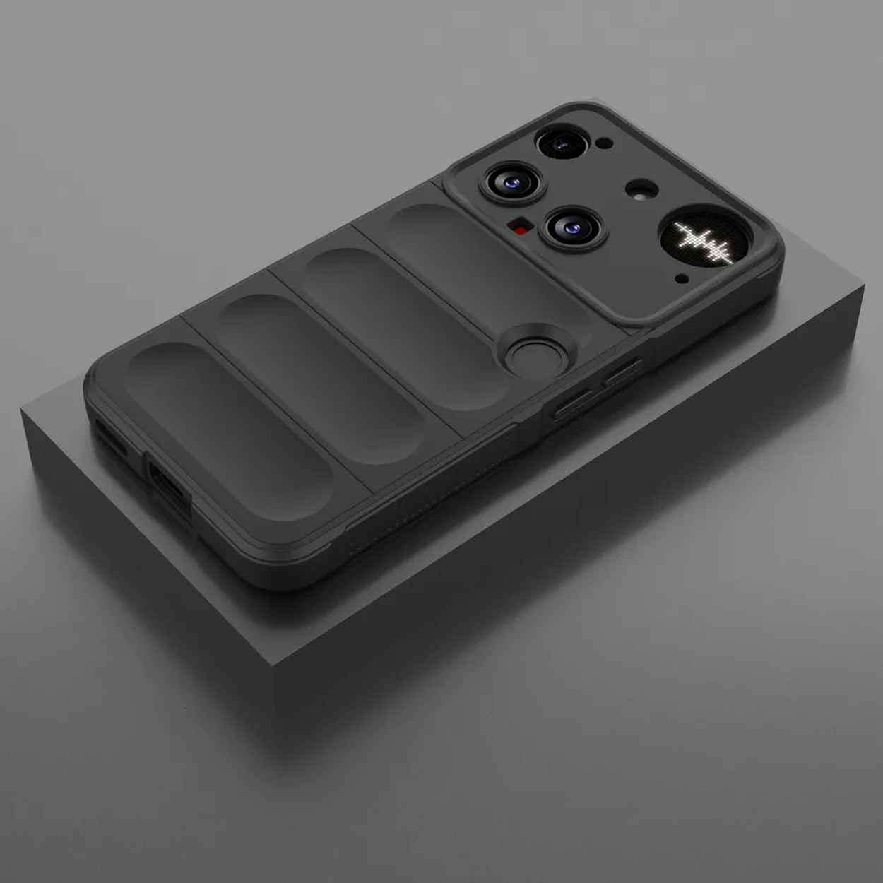 Een zwarte telefoonhoes met drie verhoogde rechthoekige secties en cameralenzen. Het ligt op een grijze kubus tegen een grijze achtergrond.