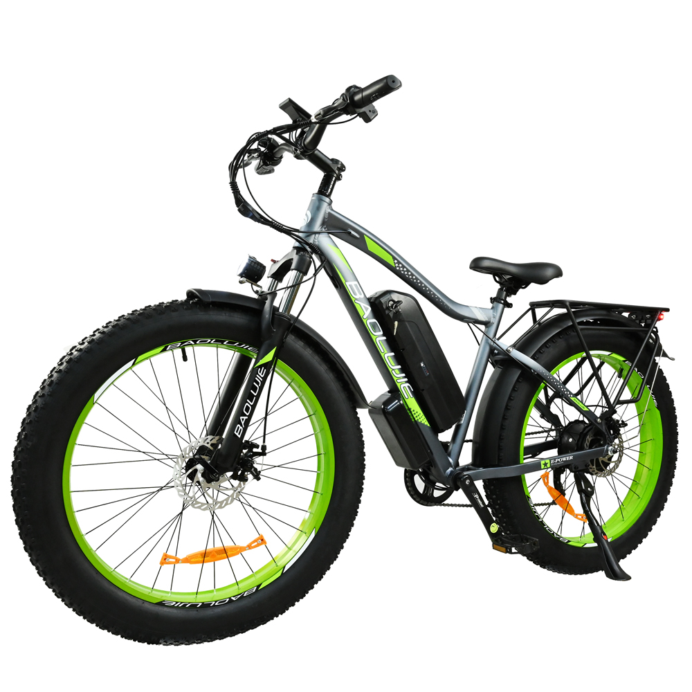 Una bicicleta eléctrica con neumáticos gruesos. Tiene un cuadro gris con detalles verdes. Las ruedas tienen llantas verdes. Asiento y batería negros.