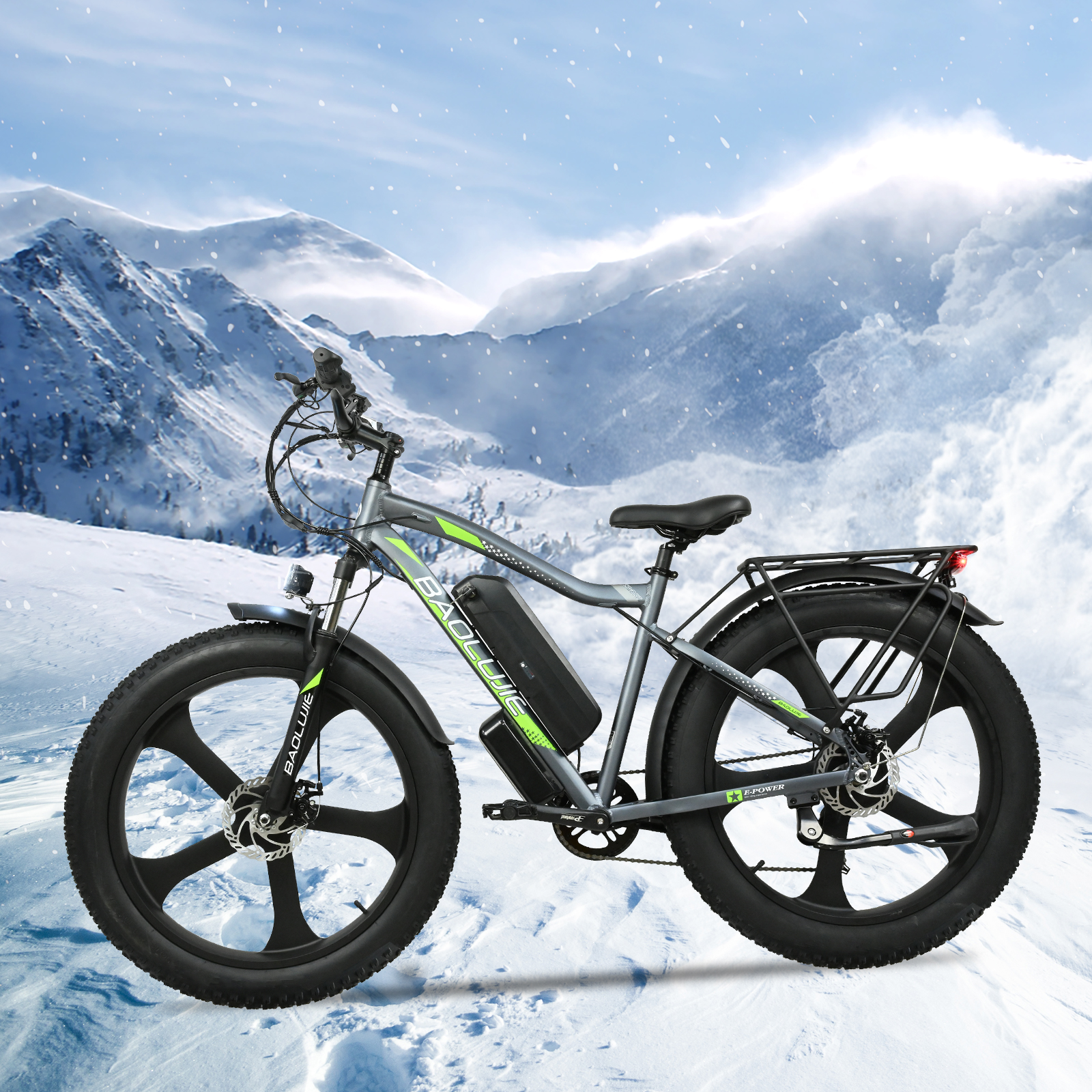 Una bicicleta eléctrica gris y negra está en una ladera nevada con montañas nevadas al fondo. Caen copos de nieve.