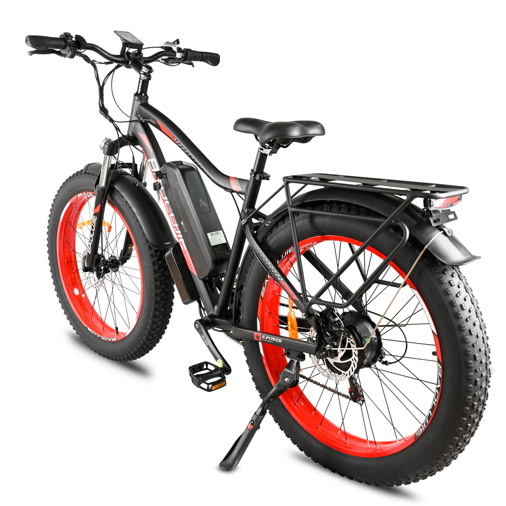 Bicicleta eléctrica negra con neumáticos de llanta roja sobre fondo blanco. Tiene batería y portaequipajes trasero. La bicicleta está inclinada a la derecha.