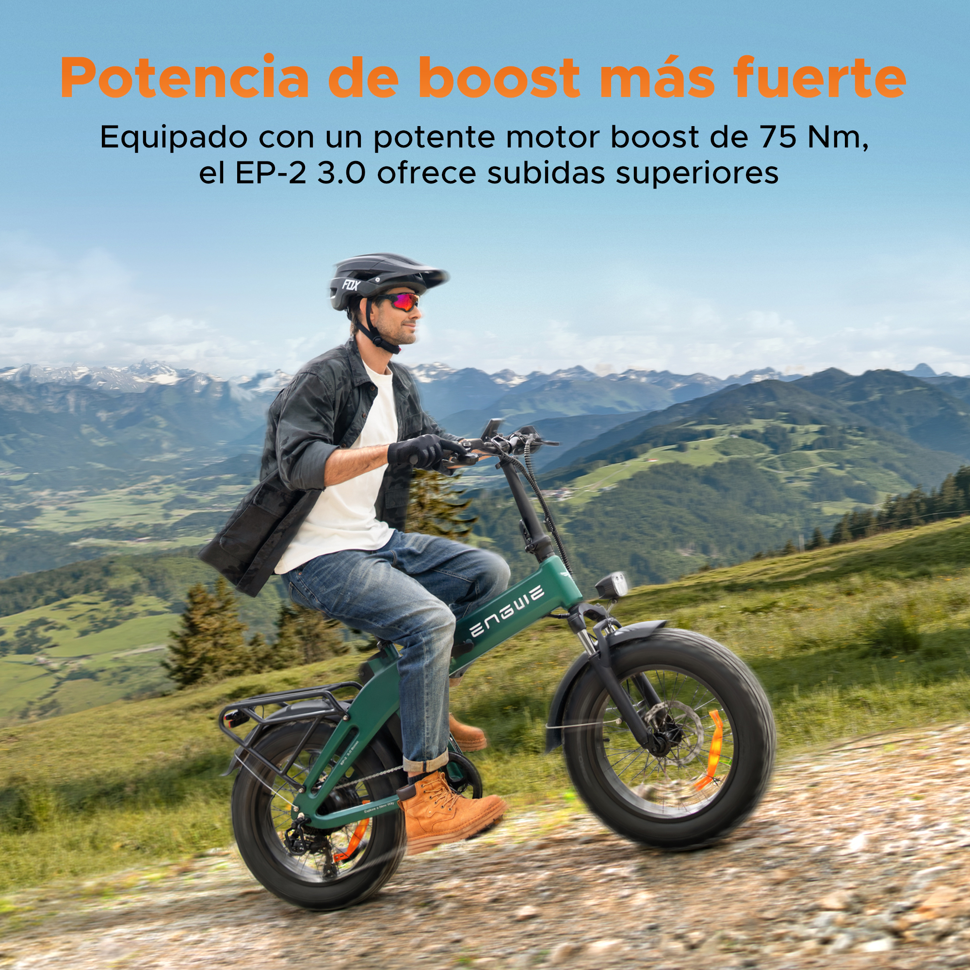 Uomo in sella a una bici elettrica su un sentiero di montagna. La bici è verde, lo sfondo mostra montagne e cielo blu.