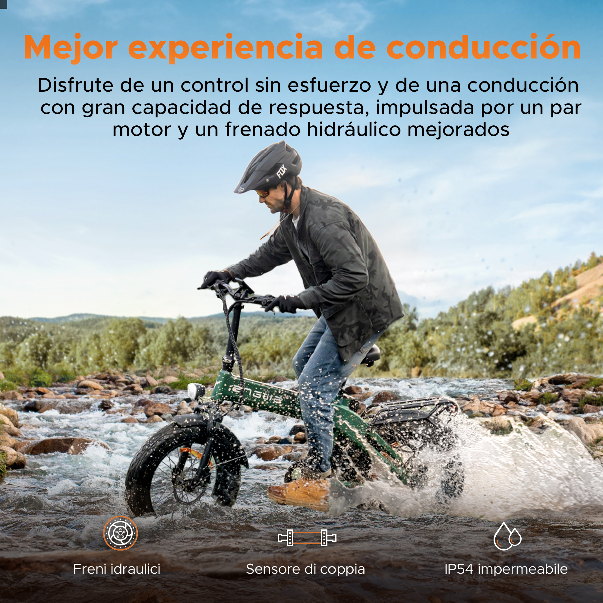 Un uomo guida una e-bike verde attraverso un ruscello. Indossa un casco e una giacca. La bici ha pneumatici larghi e schizza acqua.