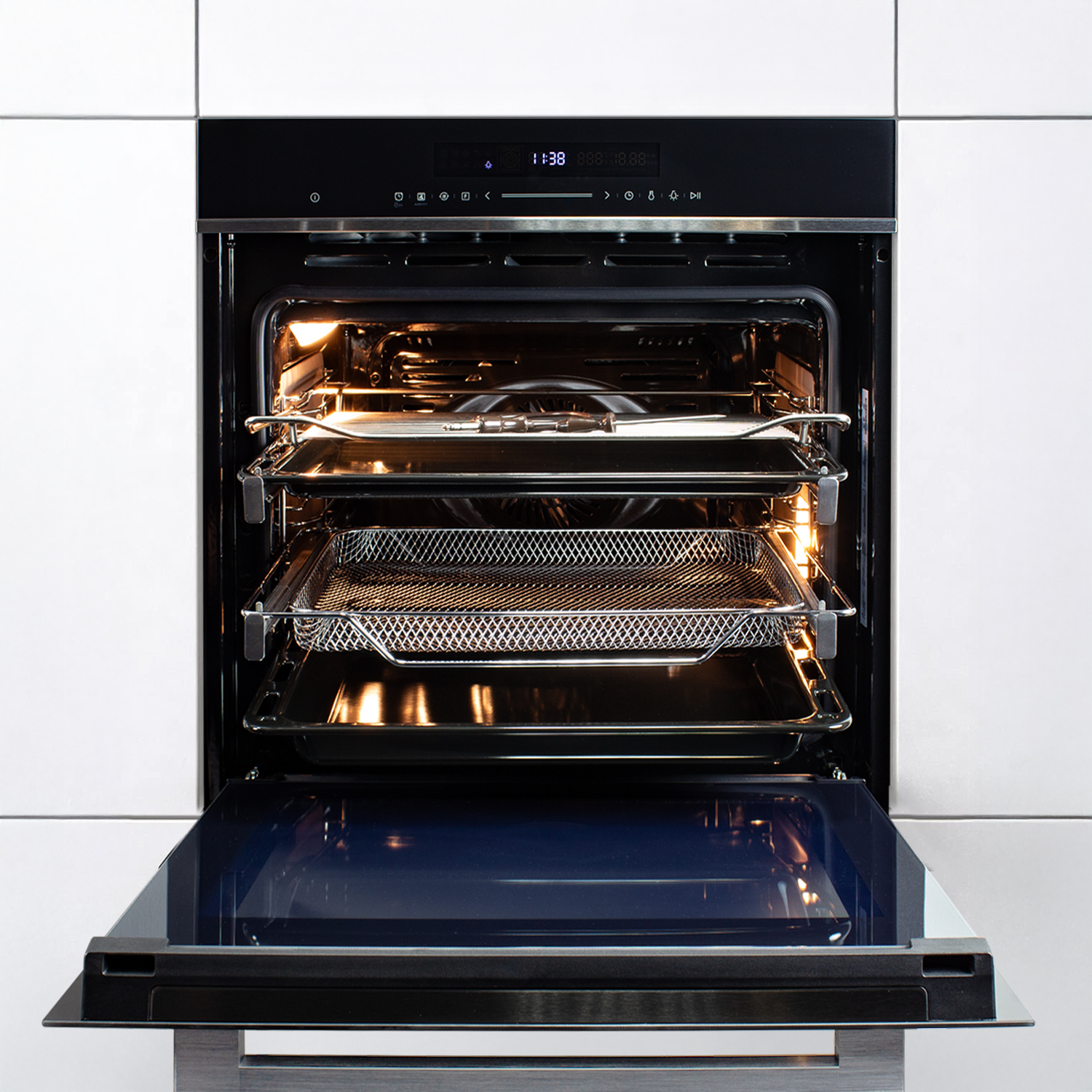 Ein offener Backofen mit Tabletts im Inneren. Die Backofentür ist unten. Die Oberseite zeigt ein digitales Display. Weiße Schränke sind im Hintergrund.