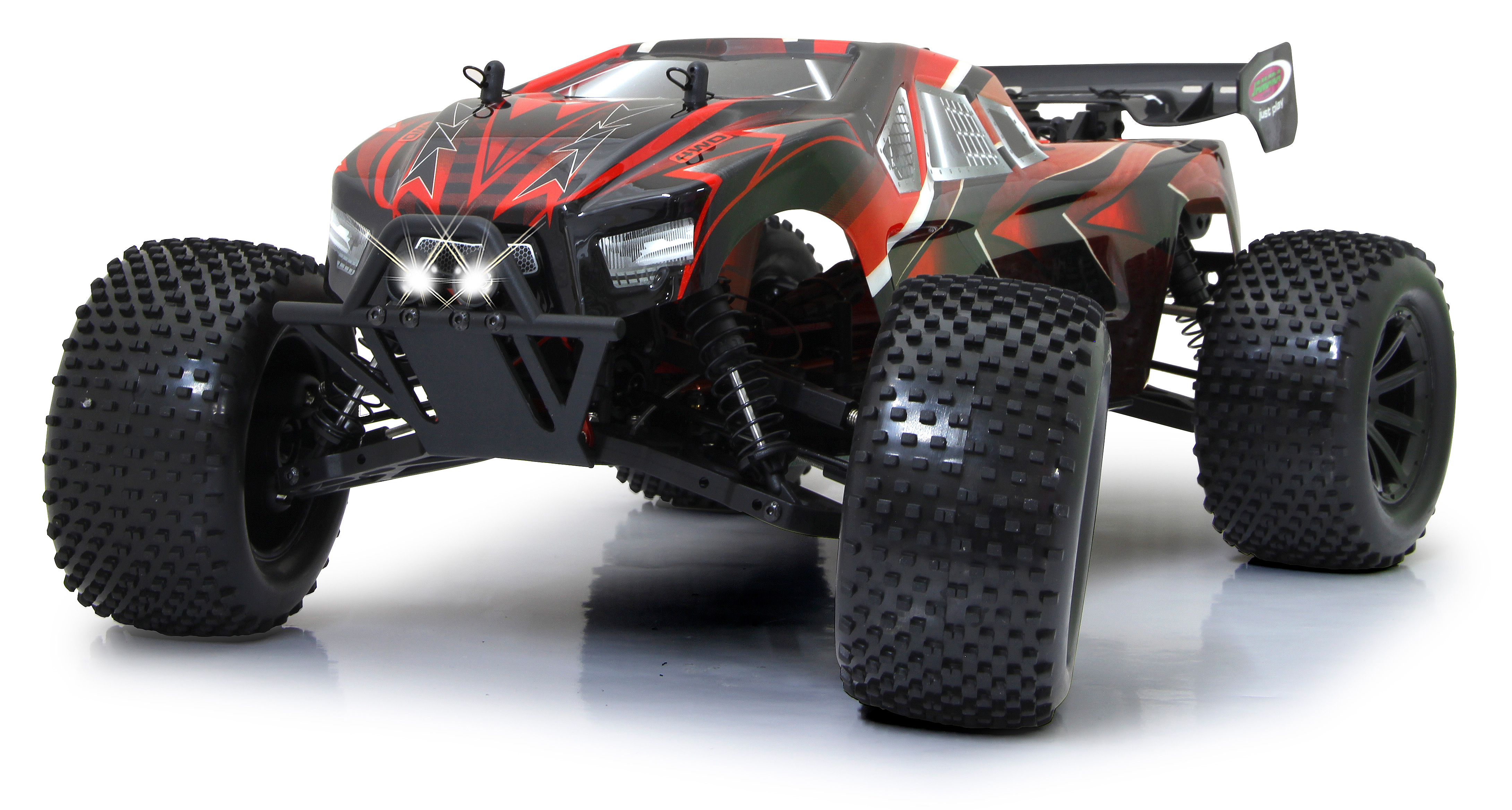 Ein rot-schwarzes RC-Auto mit großen Reifen steht auf weißem Hintergrund. Das Auto hat Lichter an.