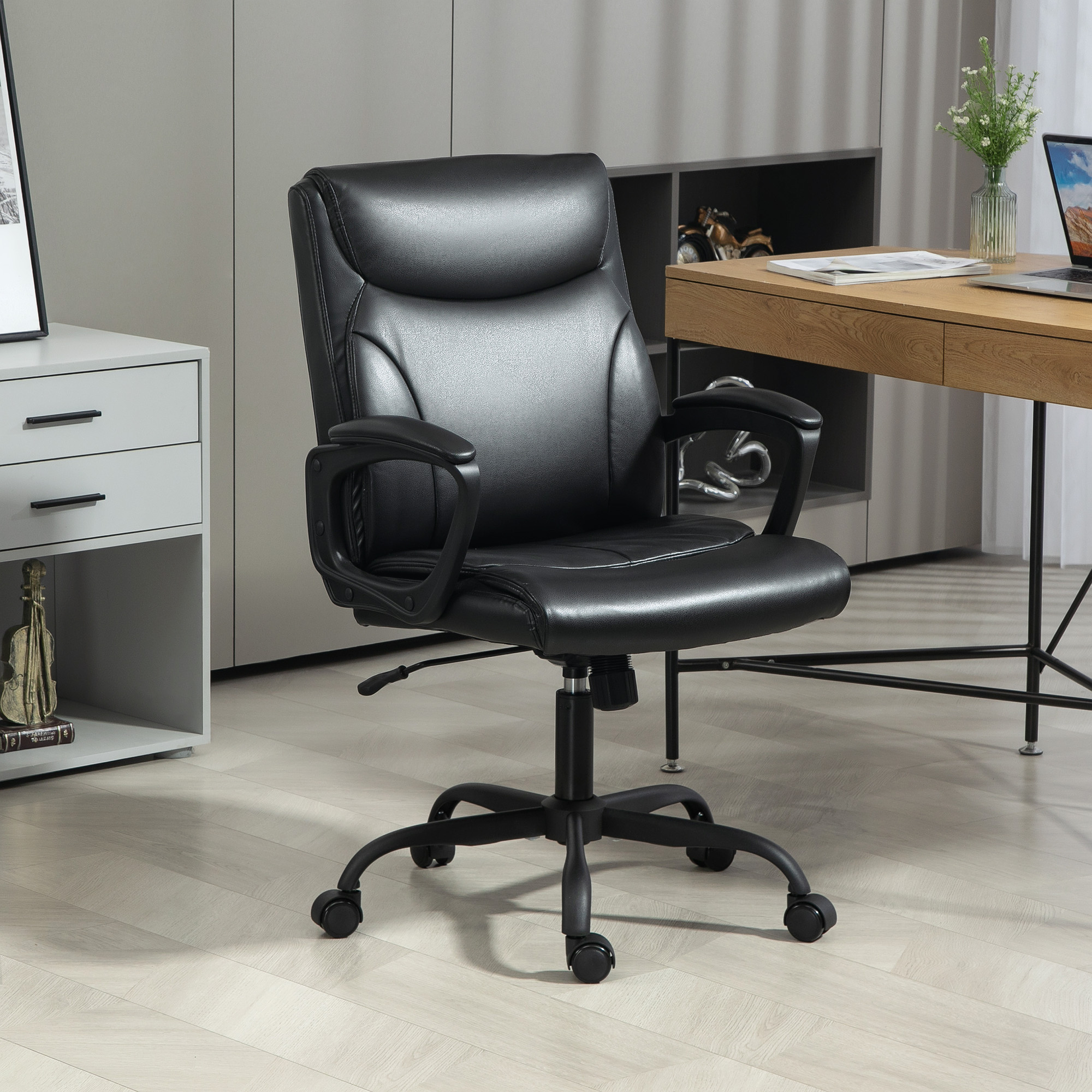 Sedia da ufficio nera in una stanza, con scrivania, cassetti e oggetti decorativi. La sedia è al centro.